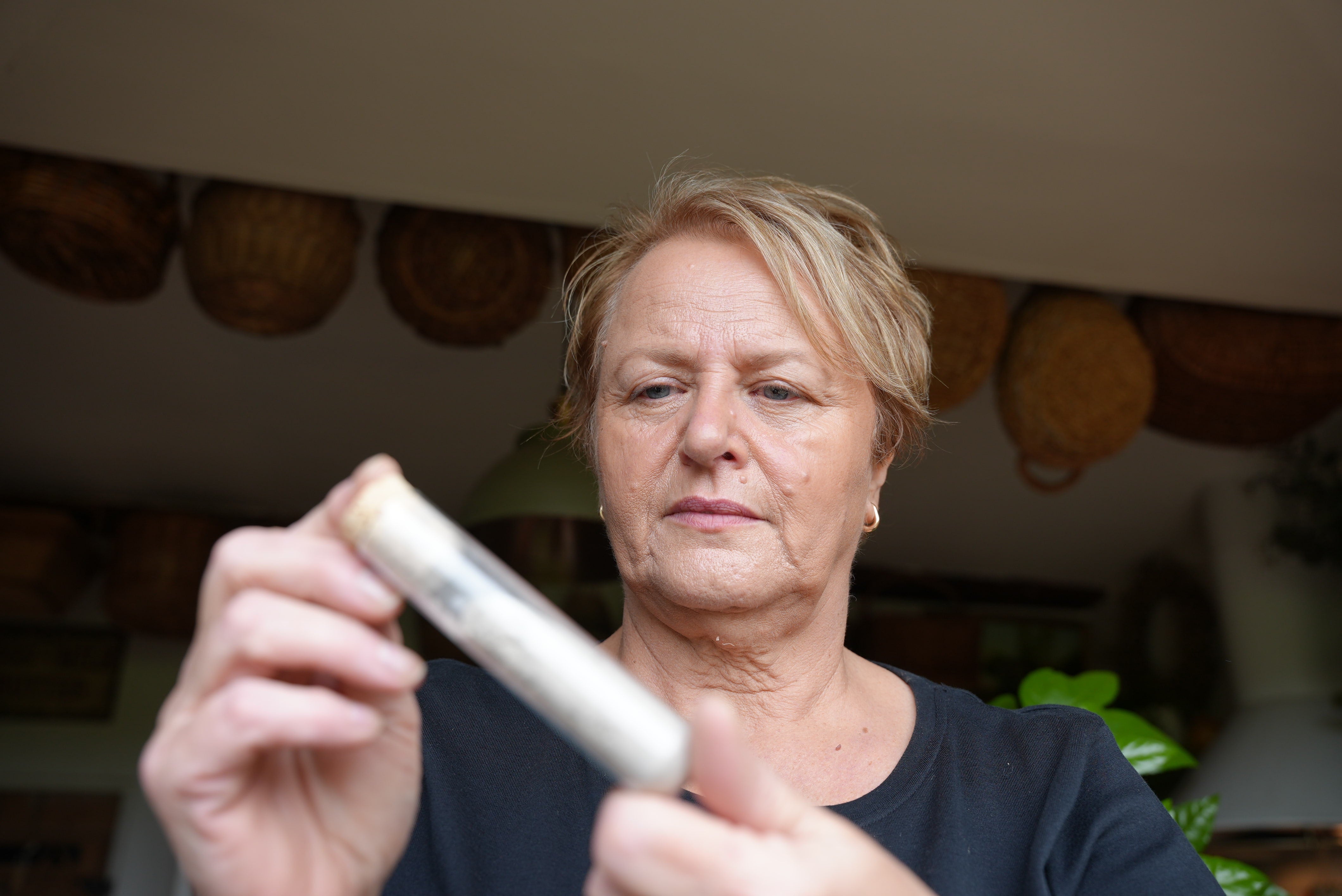 Janice Brooks, 66, looks at dusk collected from her former flat in downtown New York, in the weeks after the 11 September attacks.