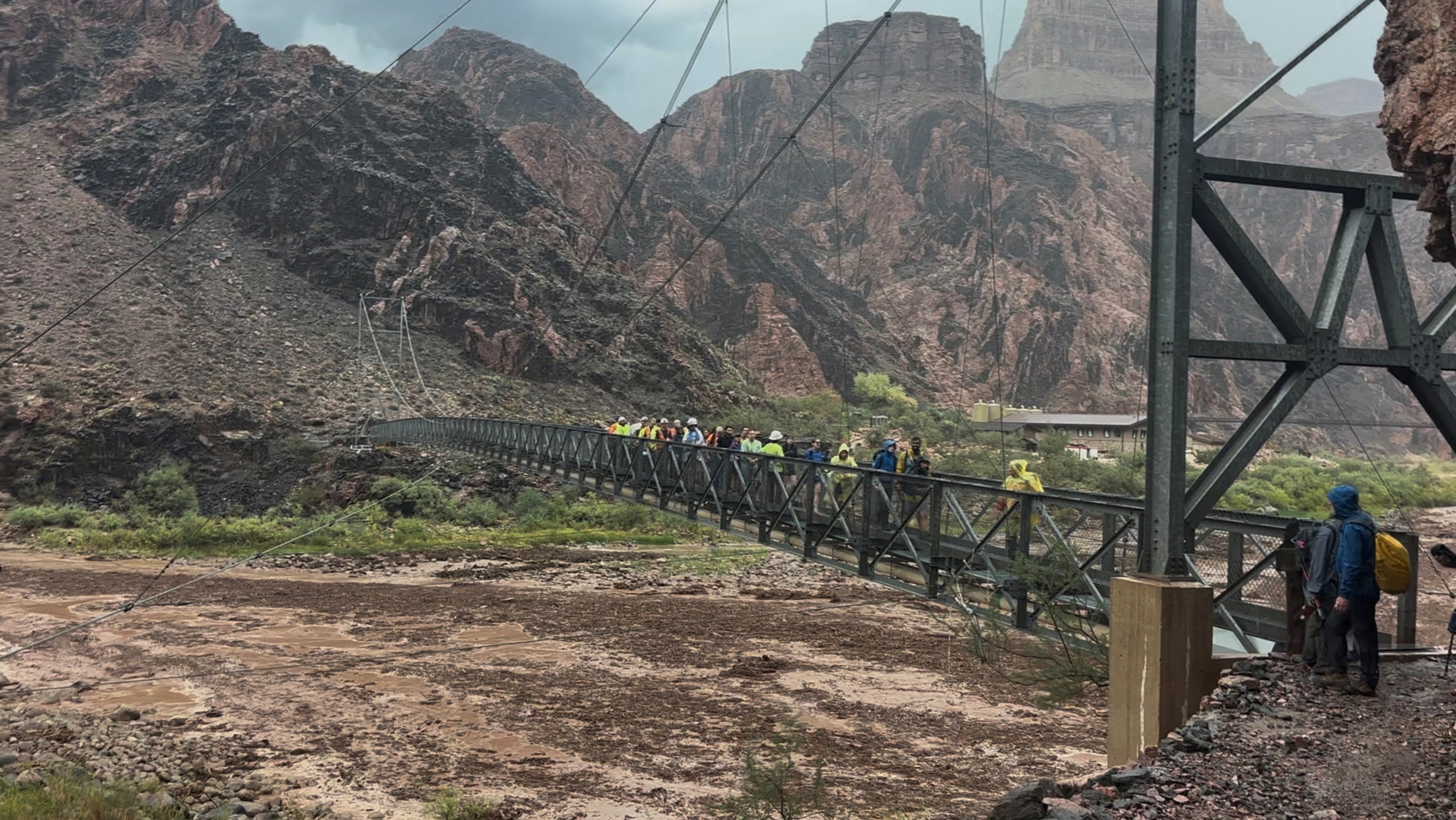 People cross a bridge amid flash flooding in Arizona’s Grand Canyon on August 29. A fast-moving storm forced the rescue of 80 people and killed two men