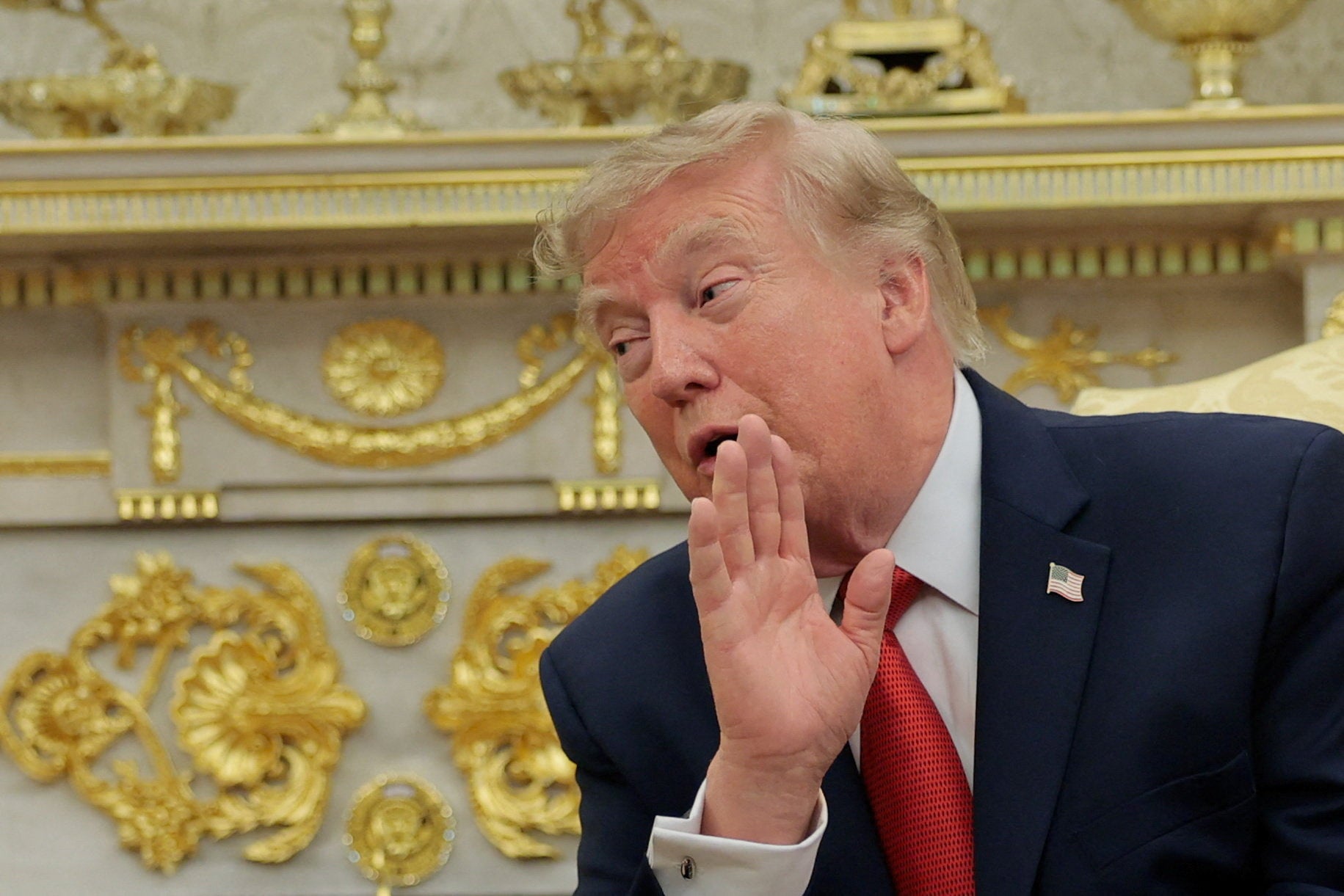 Trump is seen in front of some of the many gold-leaf accents he’s added to the Oval Office