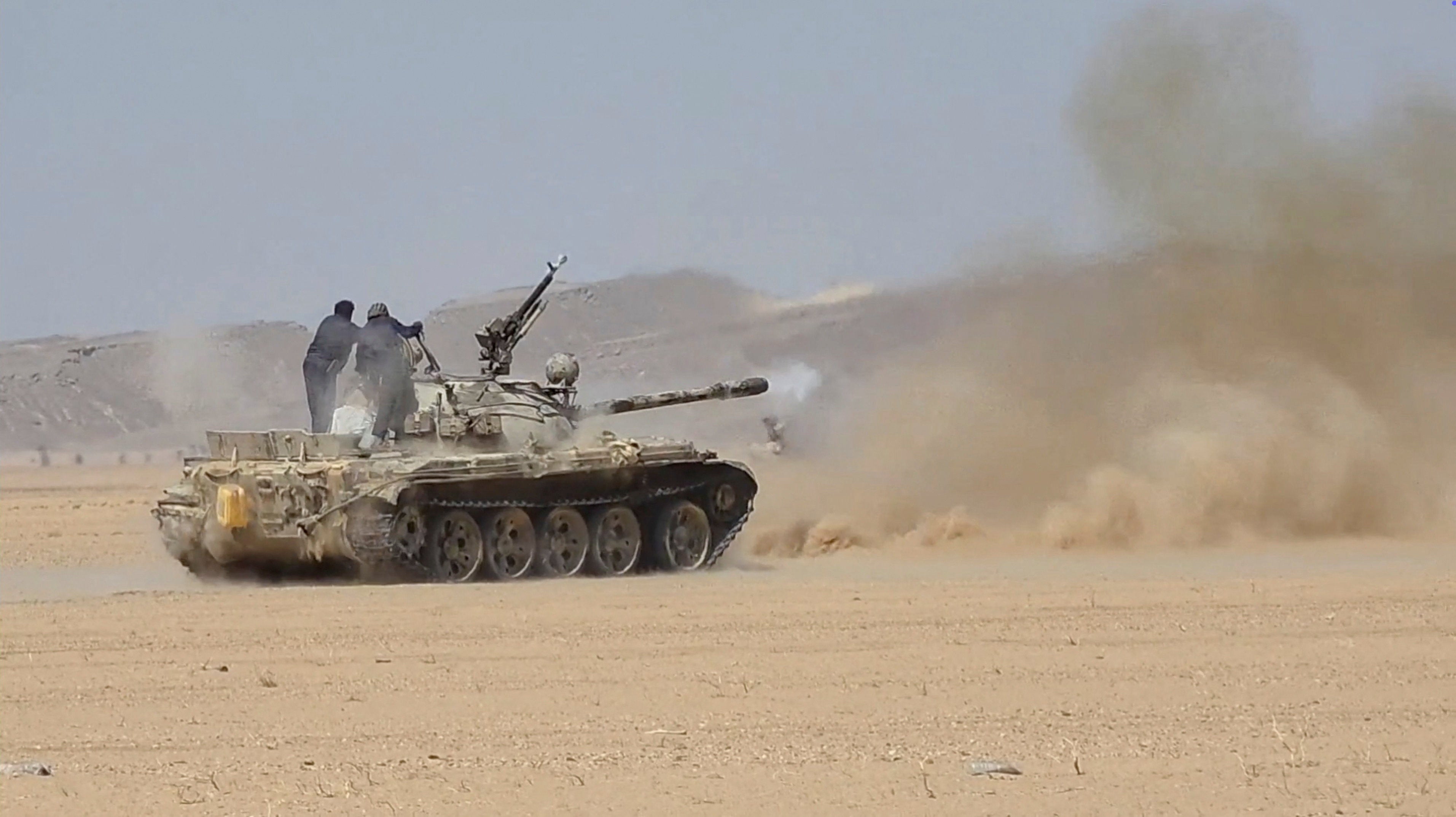 Members of the Saudi-backed Yemeni government forces fire a tank during what they say to be clashes with Yemen's Iran-aligned Houthis (Reuters)