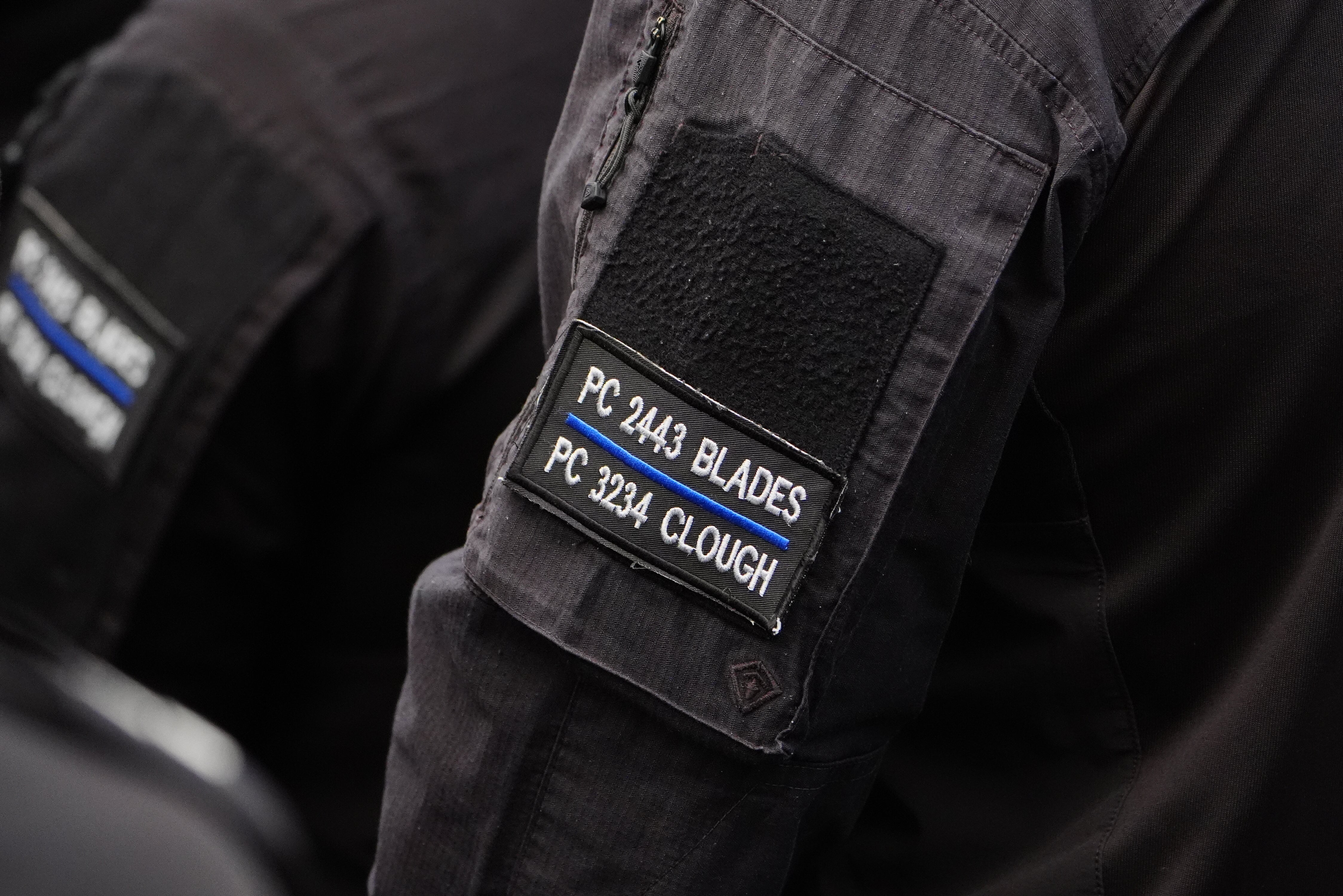 A police officer wearing a black armband embroidered with the names of Pc Blades and Pc Clough. (Owen Humphreys/PA)