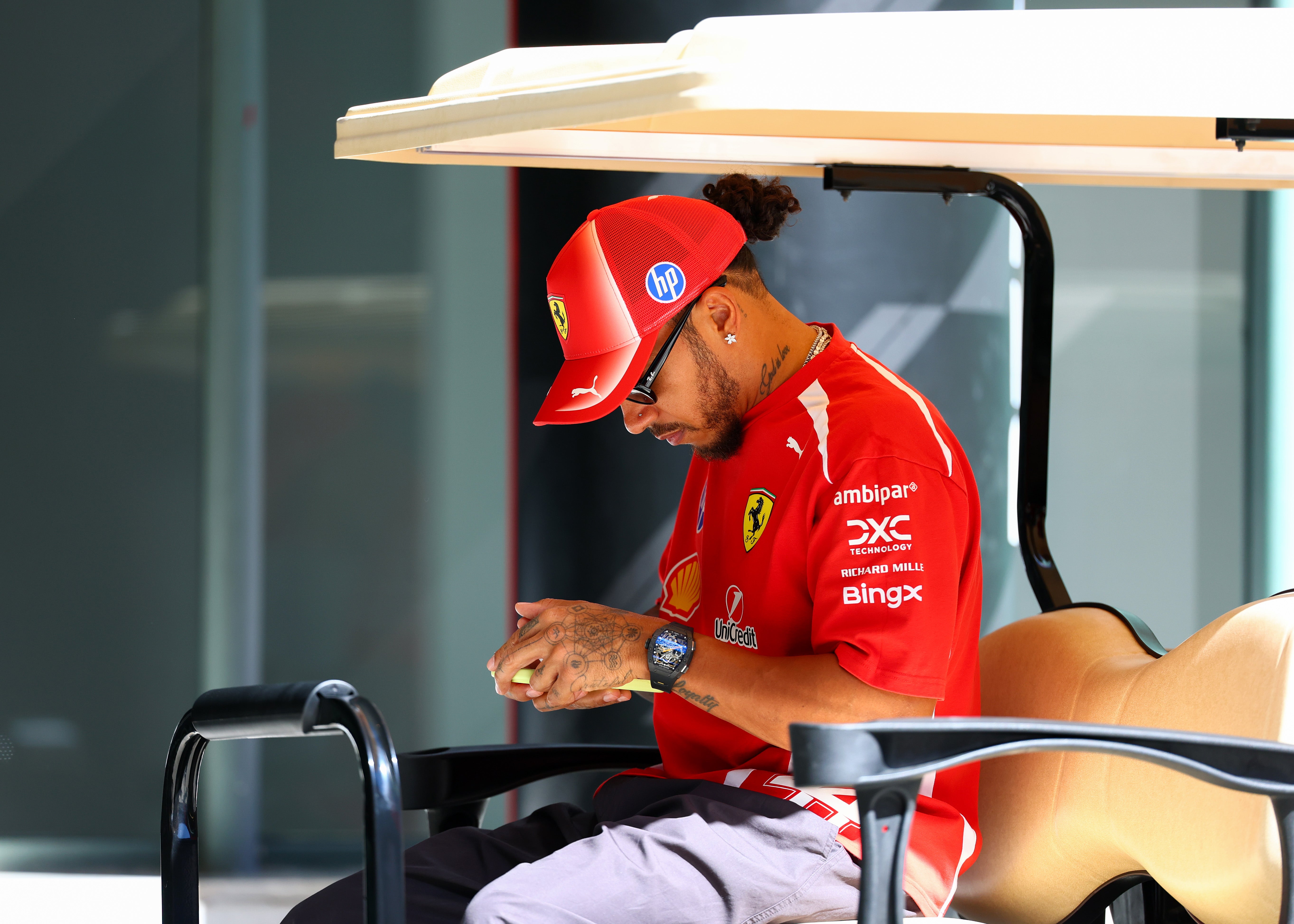 Lewis Hamilton of Great Britain and Scuderia Ferrari looks at his phone in Madrid, Spain