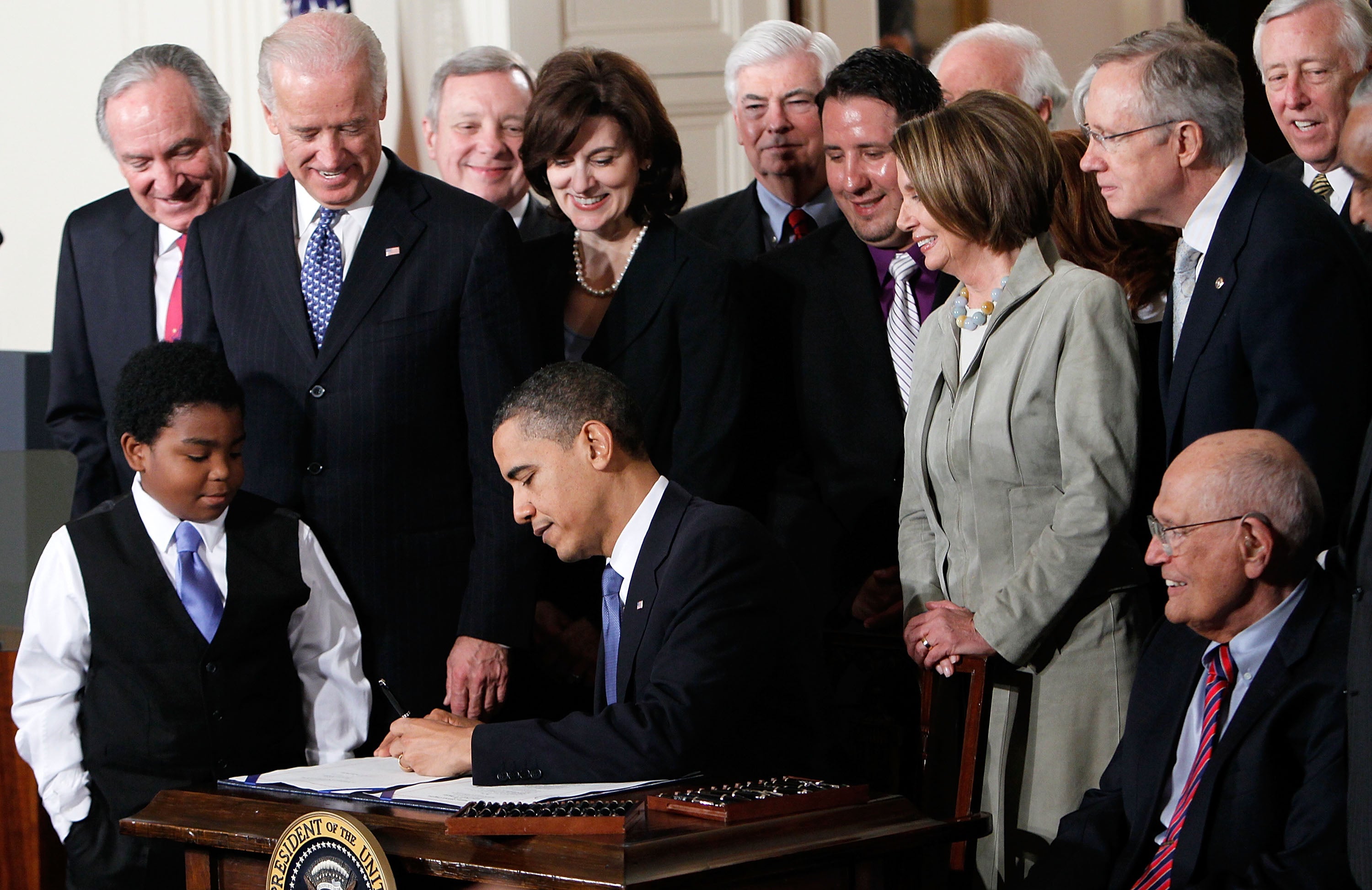 Barack Obama signs the Affordable Health Care for America Act during a ceremony with fellow Democrats in the East Room of the White House March 23, 2010 in Washington, DC