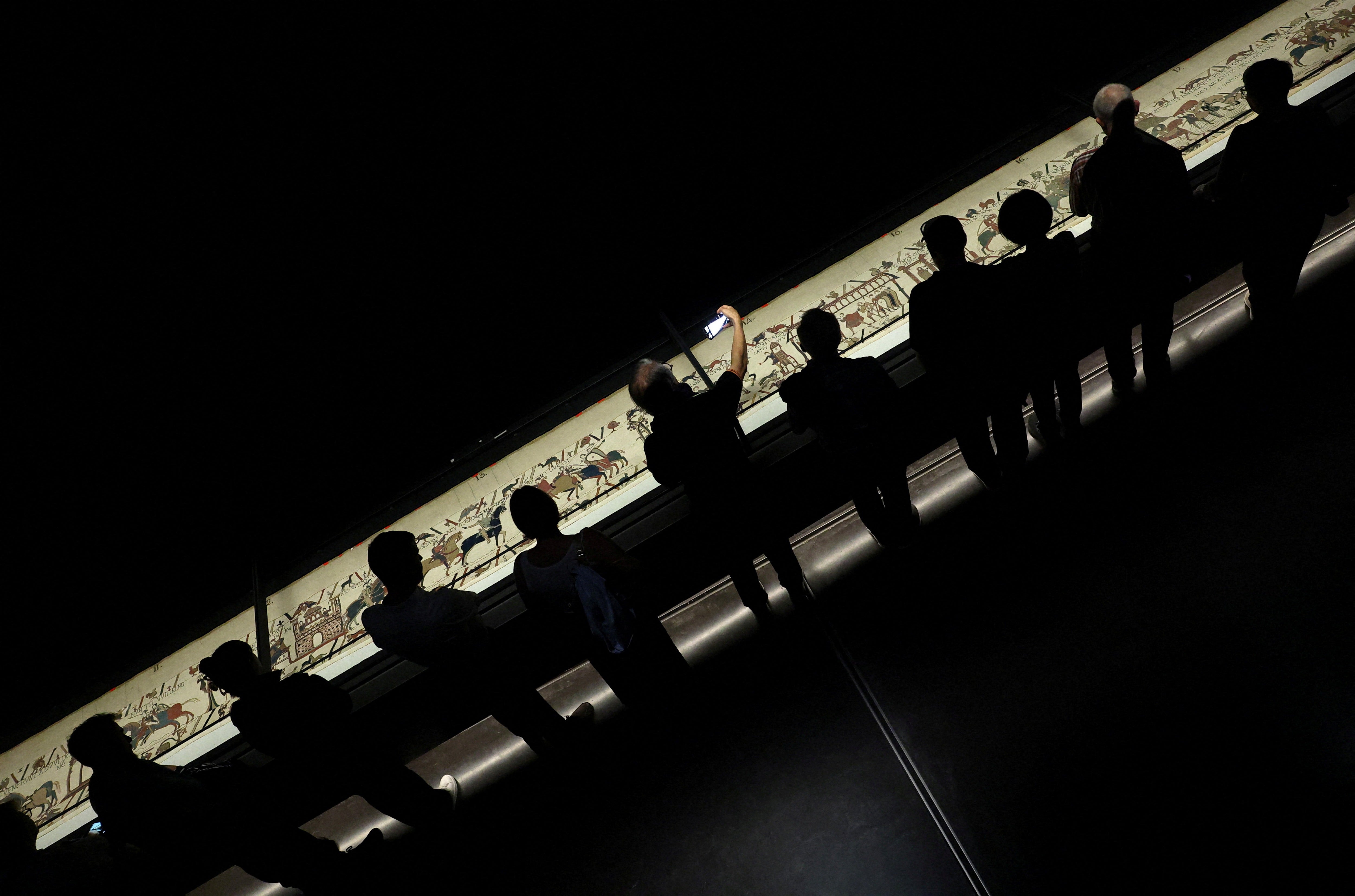 Ticket-holders view the Bayeux Tapestry from a raised platform