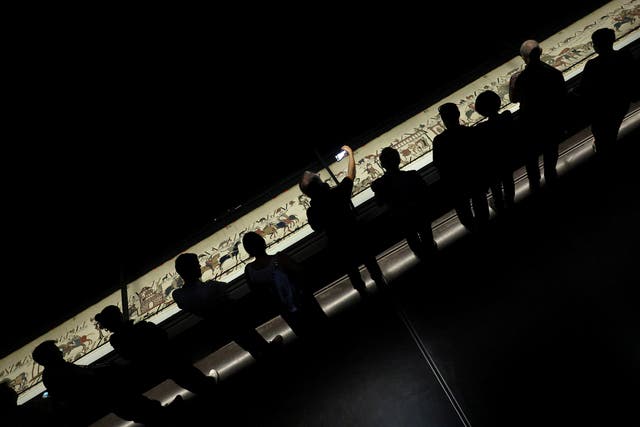 Ticket-holders view the Bayeux Tapestry from a raised platform
