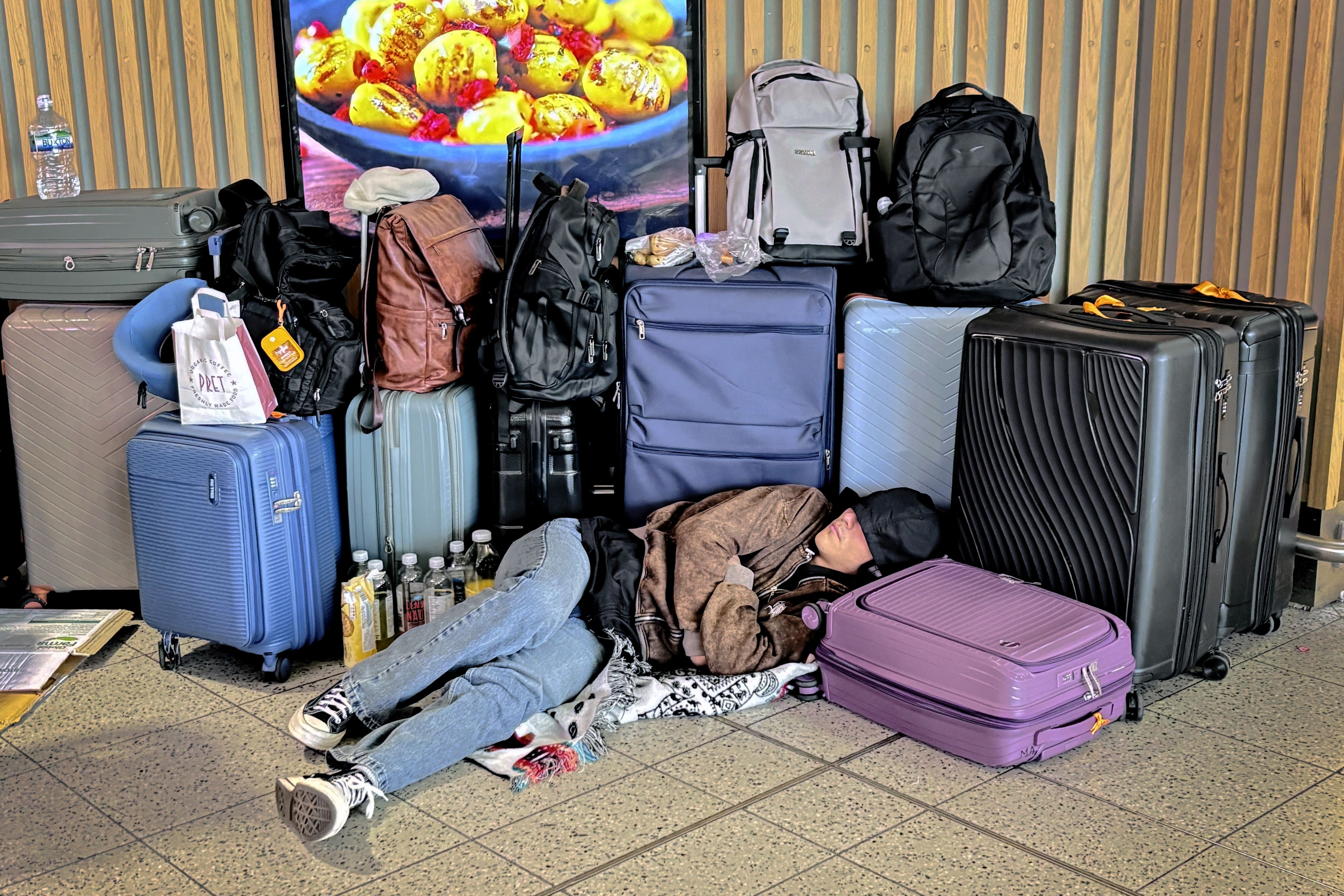 A traveler rest among their baggage while waiting for a flight. Under new federal rules, airports are no longer be forced to refund customers for a range of issues that might cause a flight delay or cancellation (PA)