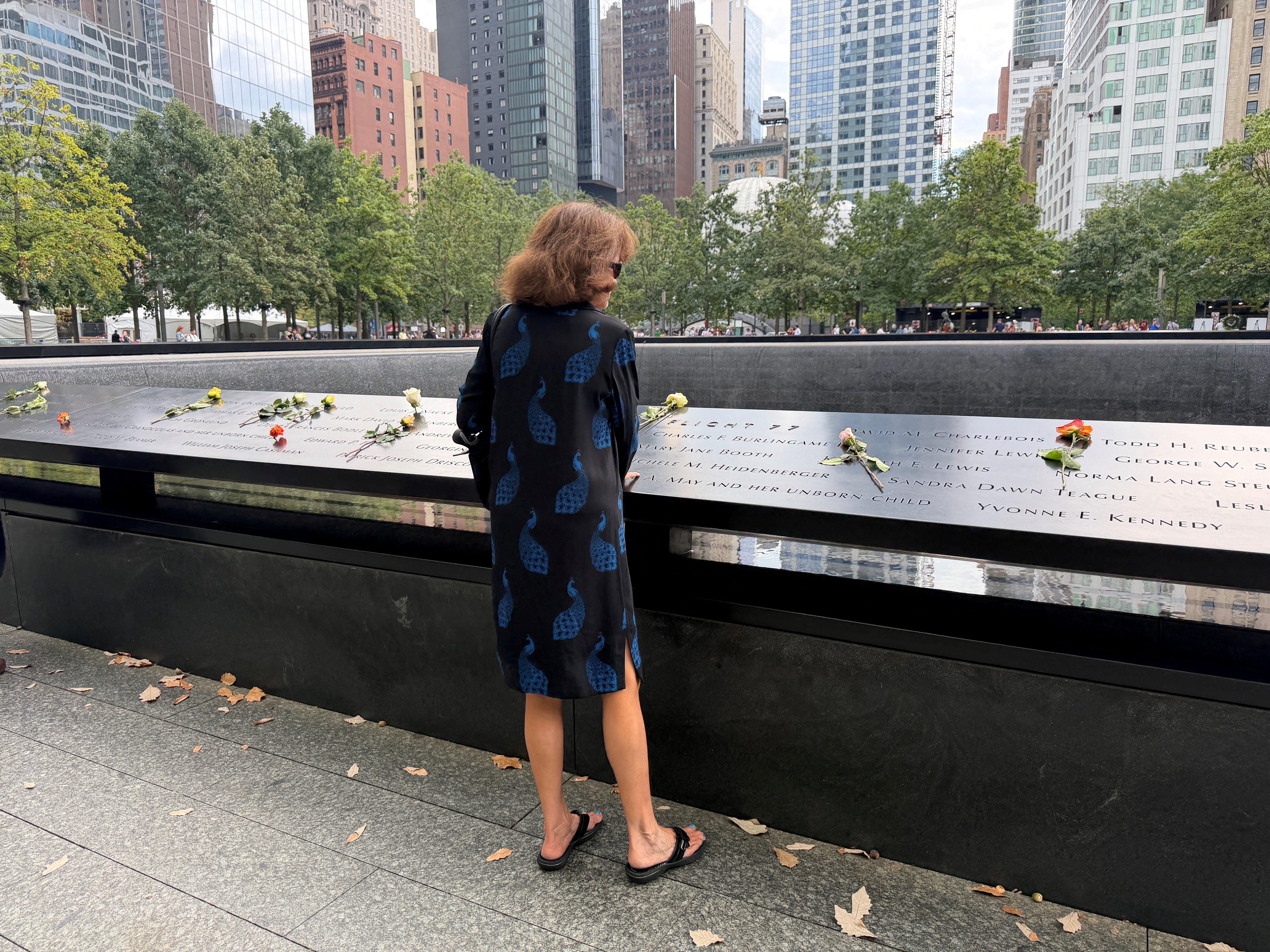 A woman looks at names on the South Pool at the 9/11 Memorial & Museum ahead of the 25th anniversary of the September 11, 2001 attacks