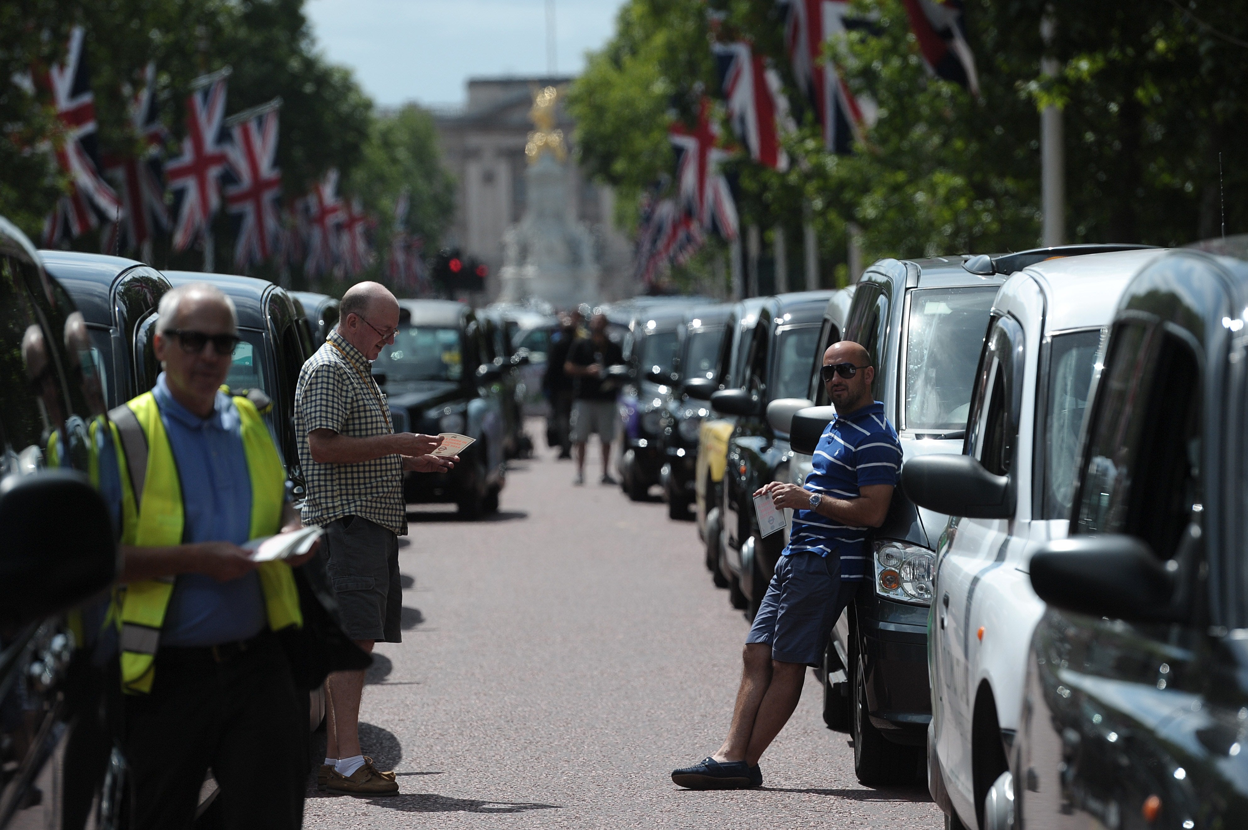 London Black Cab drivers take part in a protest against a new private taxi service 'Uber', a mobile phone app, on the Mall leading to Buckingham Palace in central London on June 11, 2014