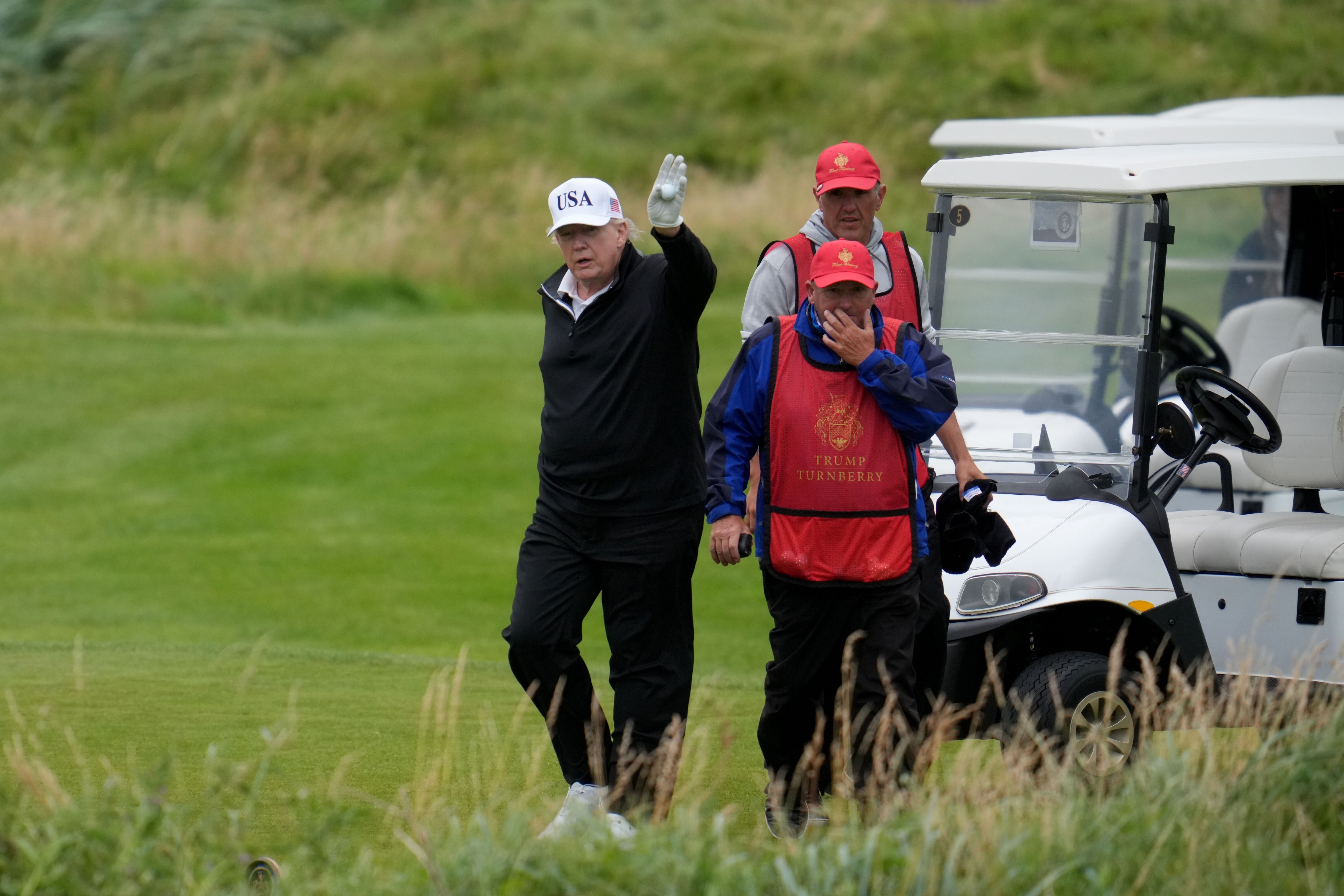 Donald Trump waves as he plays a round of golf at Trump Turnberry golf course during his visit to the UK on July 27, 2025 in Turnberry, Scotland