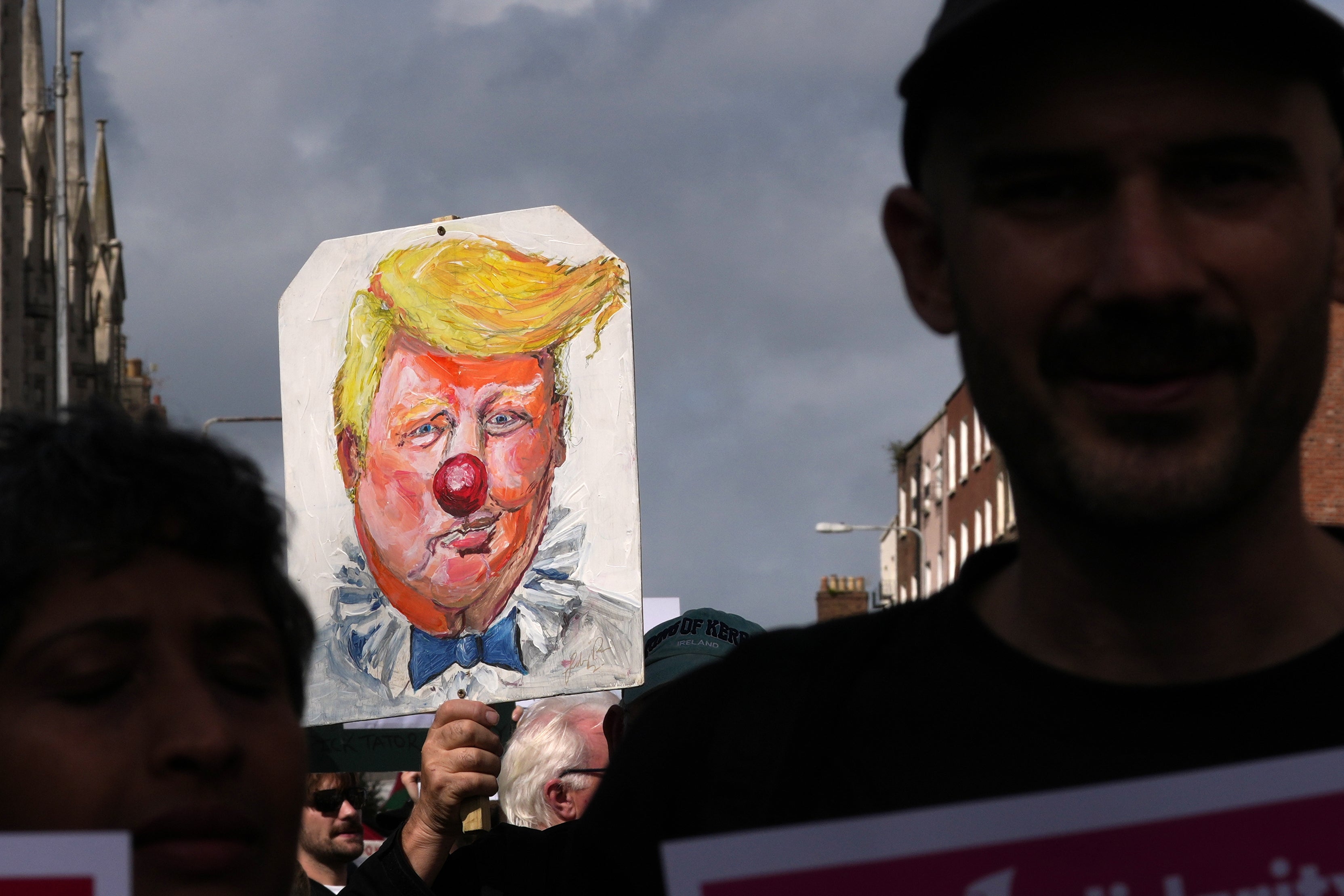 Protesters show placards during a demonstration against the visit of U.S. President Donald Trump in Dublin, Saturday, Sept. 12,