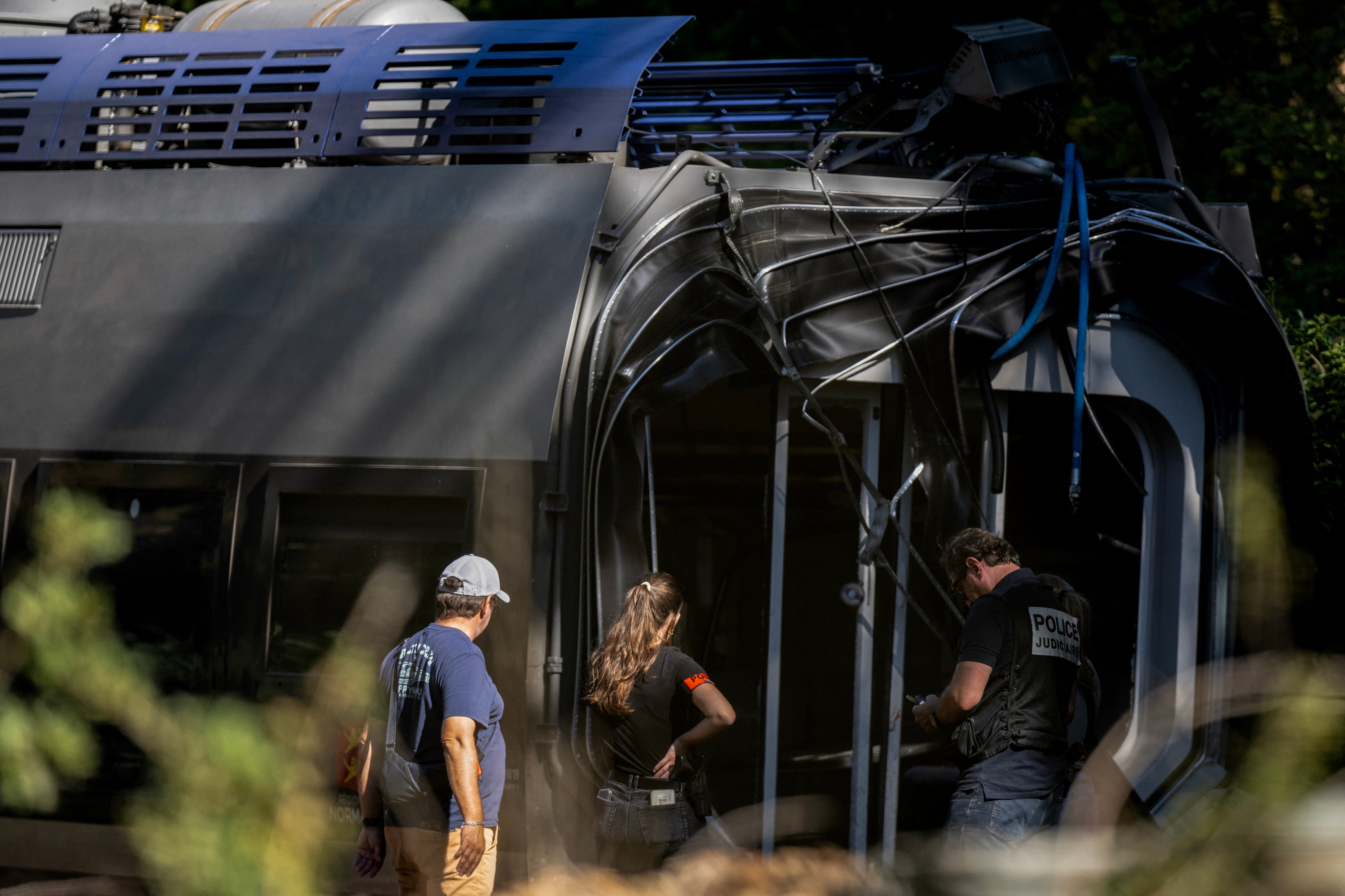 Police officers investigate on the site, after a train derailed yesterday evening while carrying 186 passengers, injuring 44 people, one of them seriously, in Cleon, northwestern France