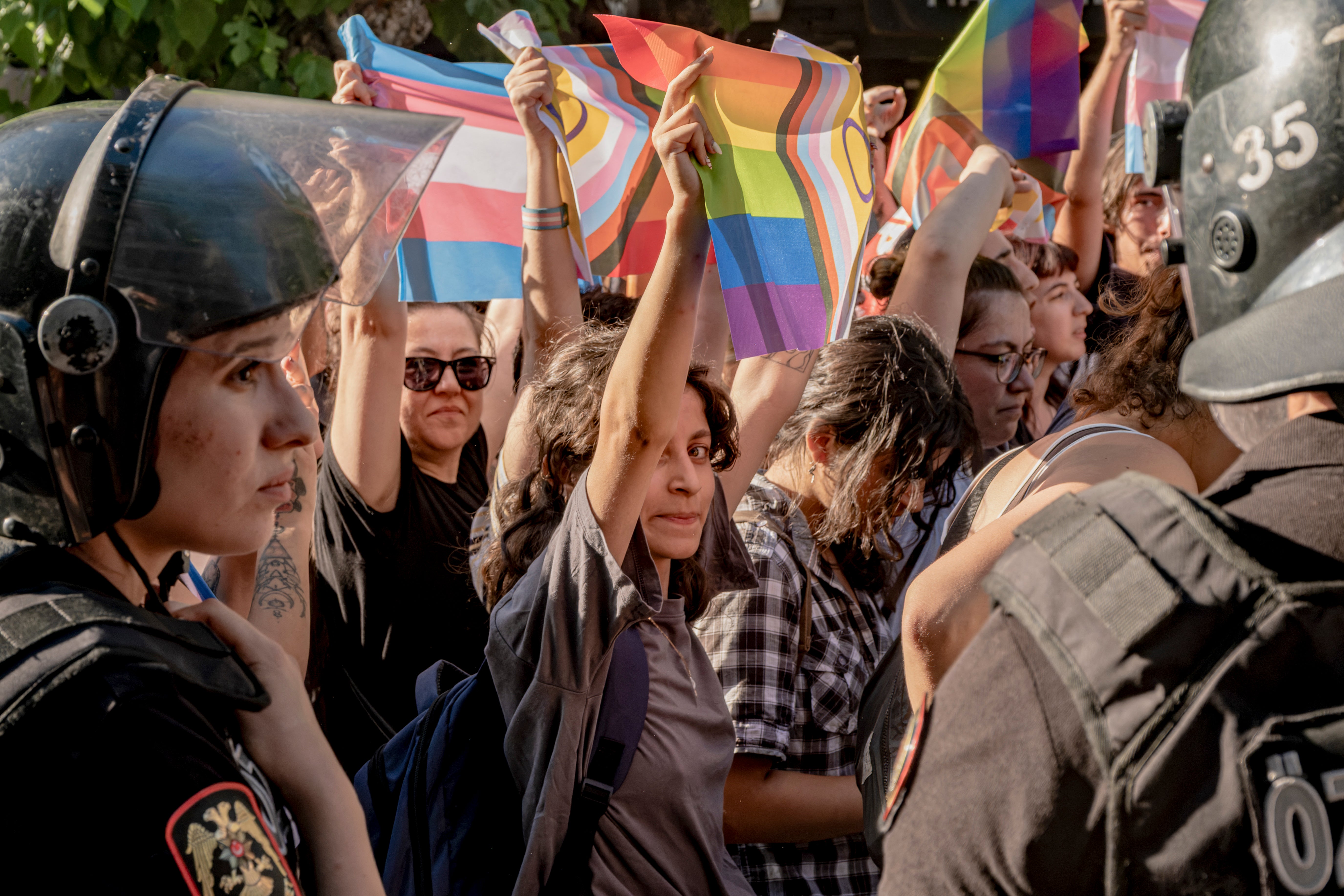 Protesters hold up Pride flags as they stand in front of riot police officers in Izmir, Turkey, on June 27, 2026