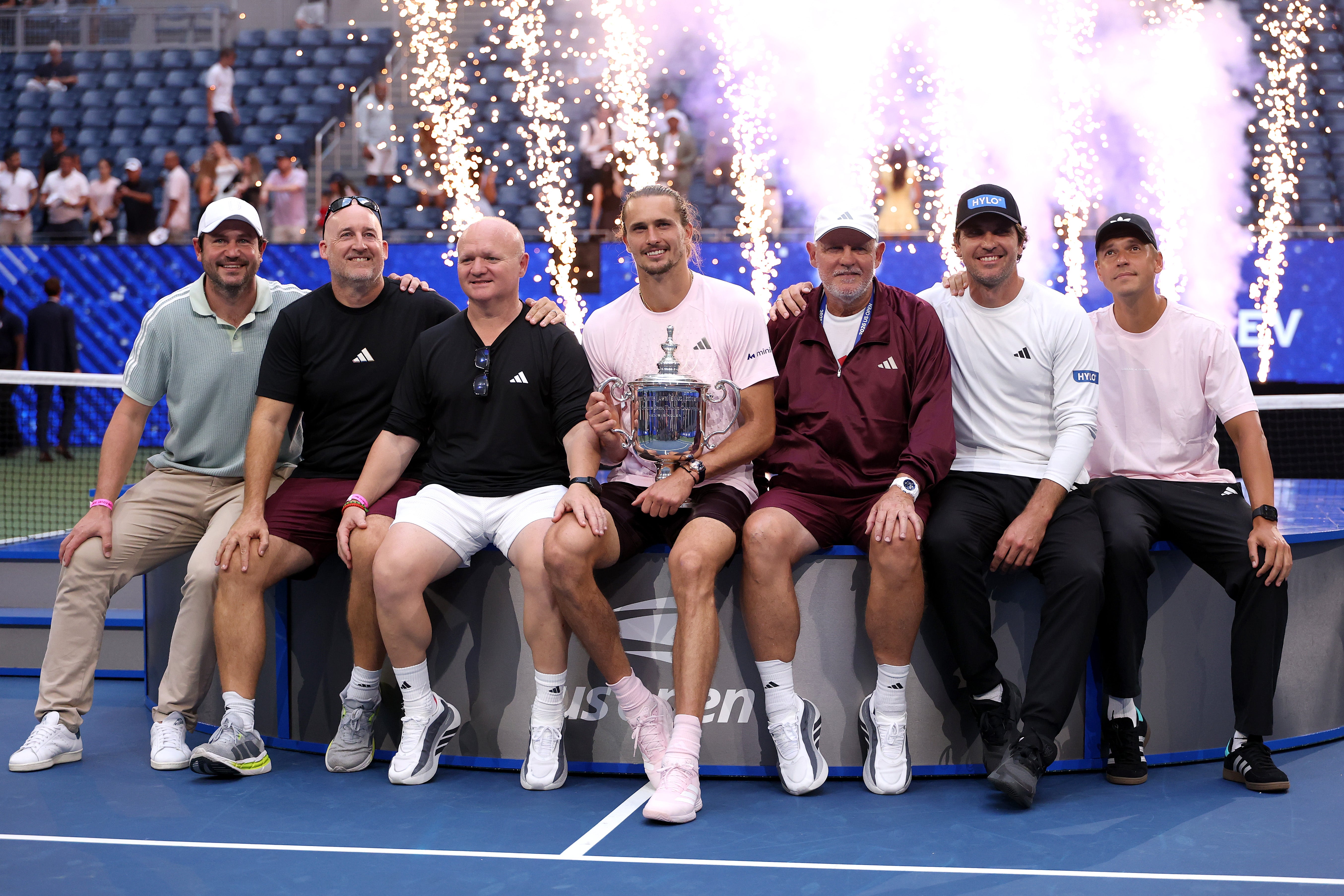 Alexander Zverev poses with the trophy and his coaches after defeating Ben Shelton