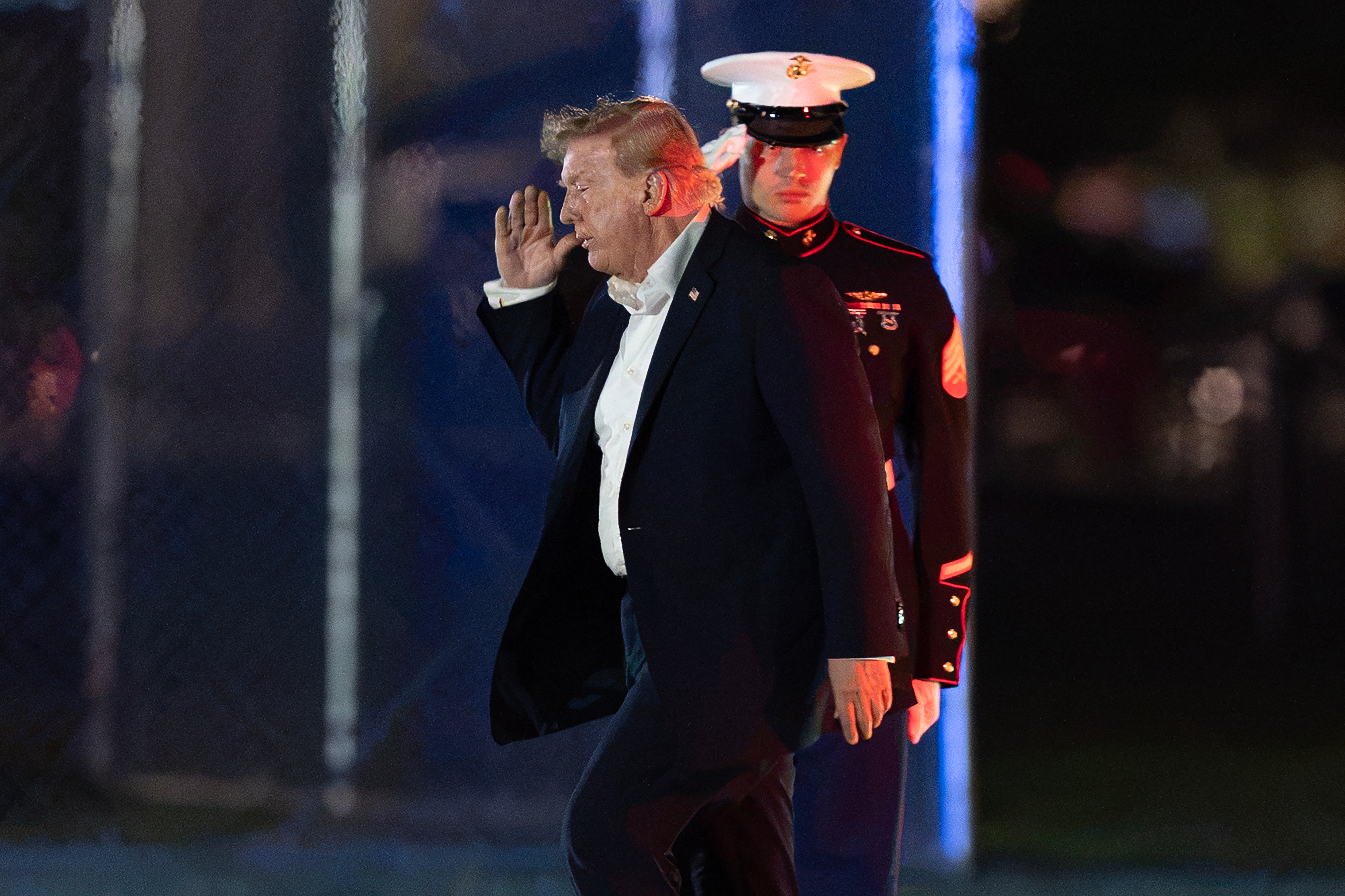 President Donald Trump returns a salute as he walks from Marine One to his limousine upon his arrival at the Ellipse just outside of the White House