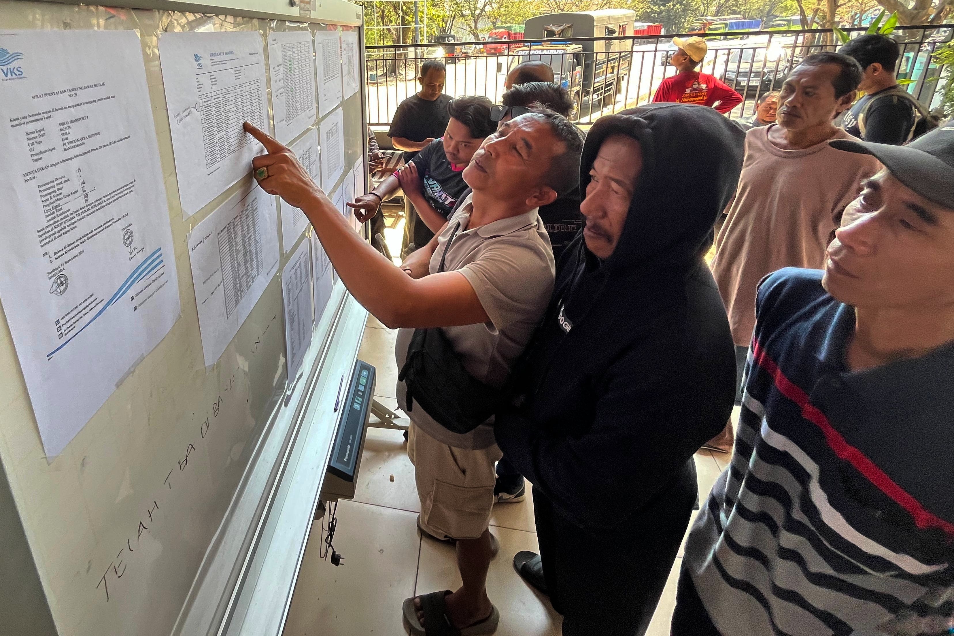 People check the passenger manifest of Virgo Transport 8 passenger ferry which overturned in bad weather in the Java Sea, at the rescuers' command center in Banjarmasin, South Kalimantan, Indonesia, Monday, 14 Sept 2026