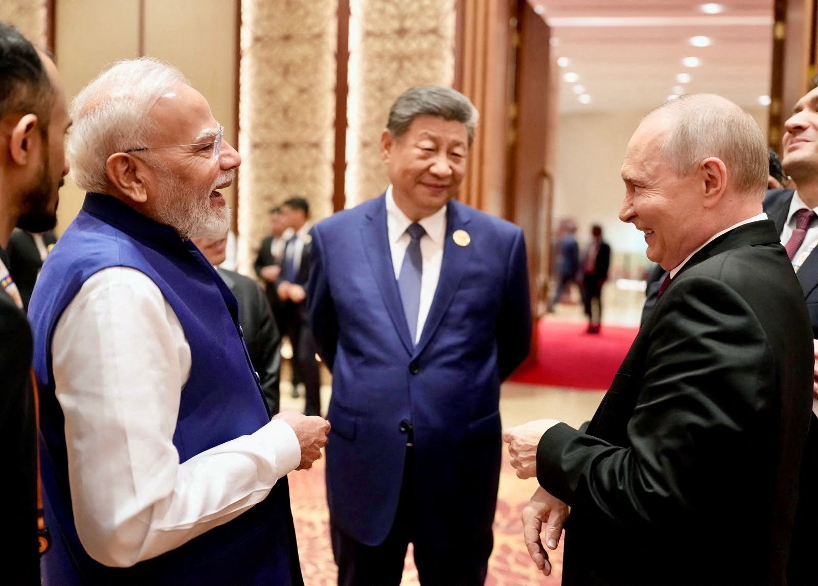 India's Prime Minister Narendra Modi shares a moment with Russian President Vladimir Putin as Chinese President Xi Jinping looks on during day two of the BRICS Summit in New Delhi, India (Reuters)