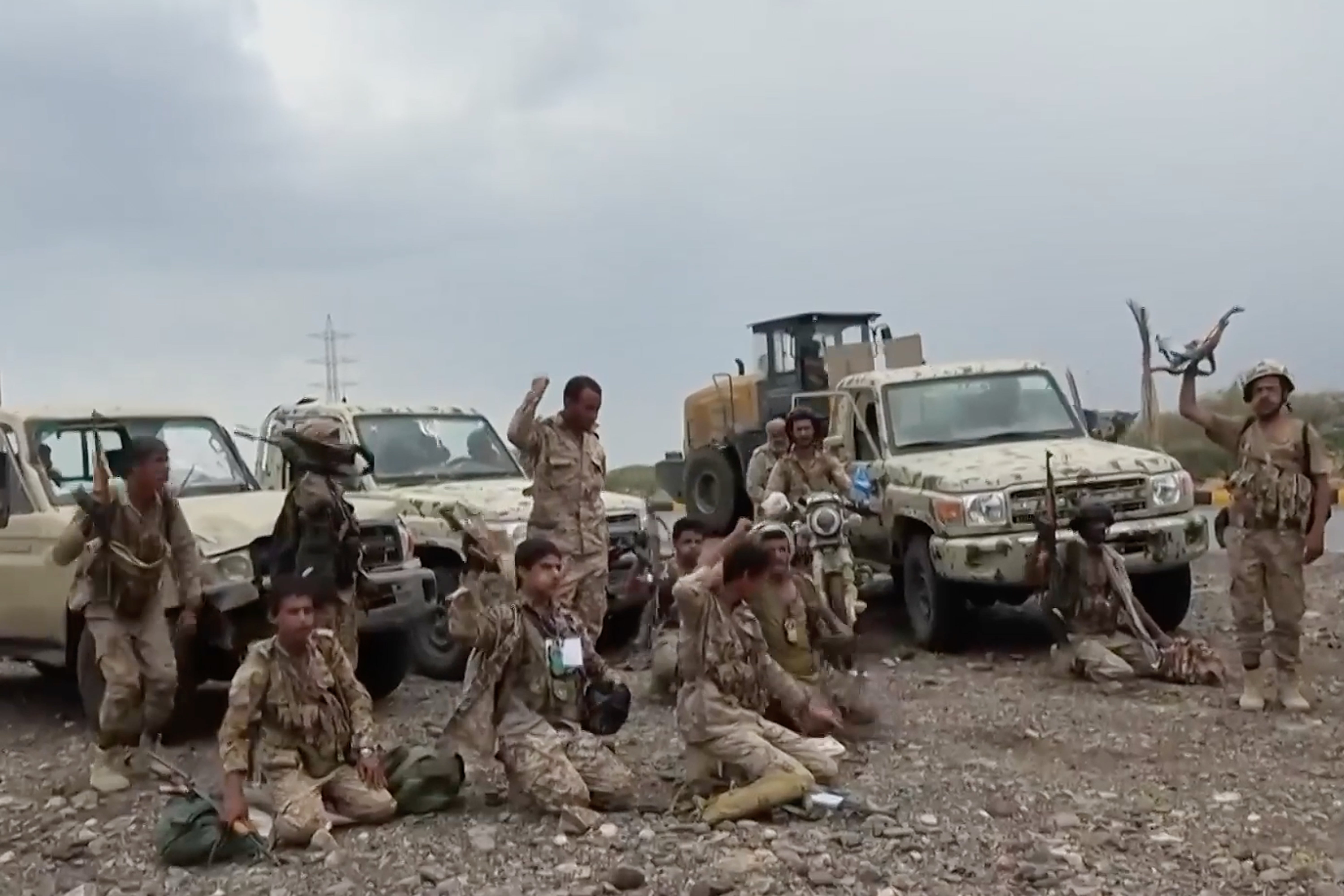 Houthi fighters chant after praying beside military vehicles during what the group says was their advance against Saudi-backed forces at an undisclosed location in southern Yemen, on 12 September
