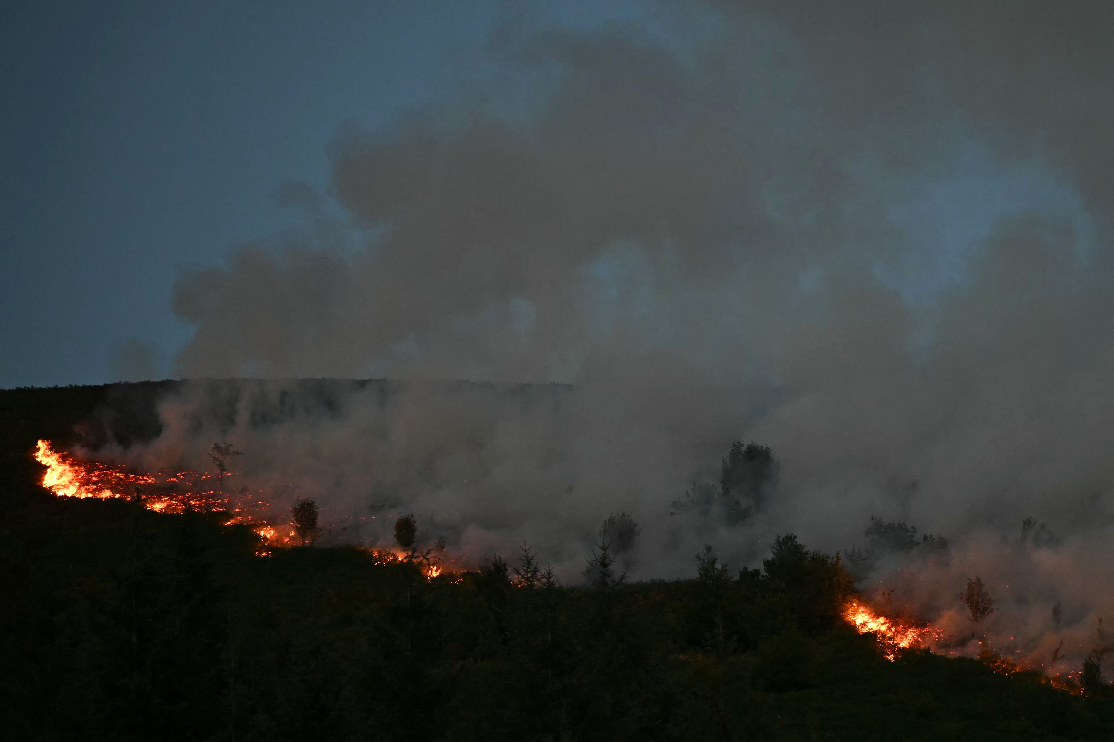 Smoke rises from burning moorland near in south Wales after a wildfire broke out on August 15
