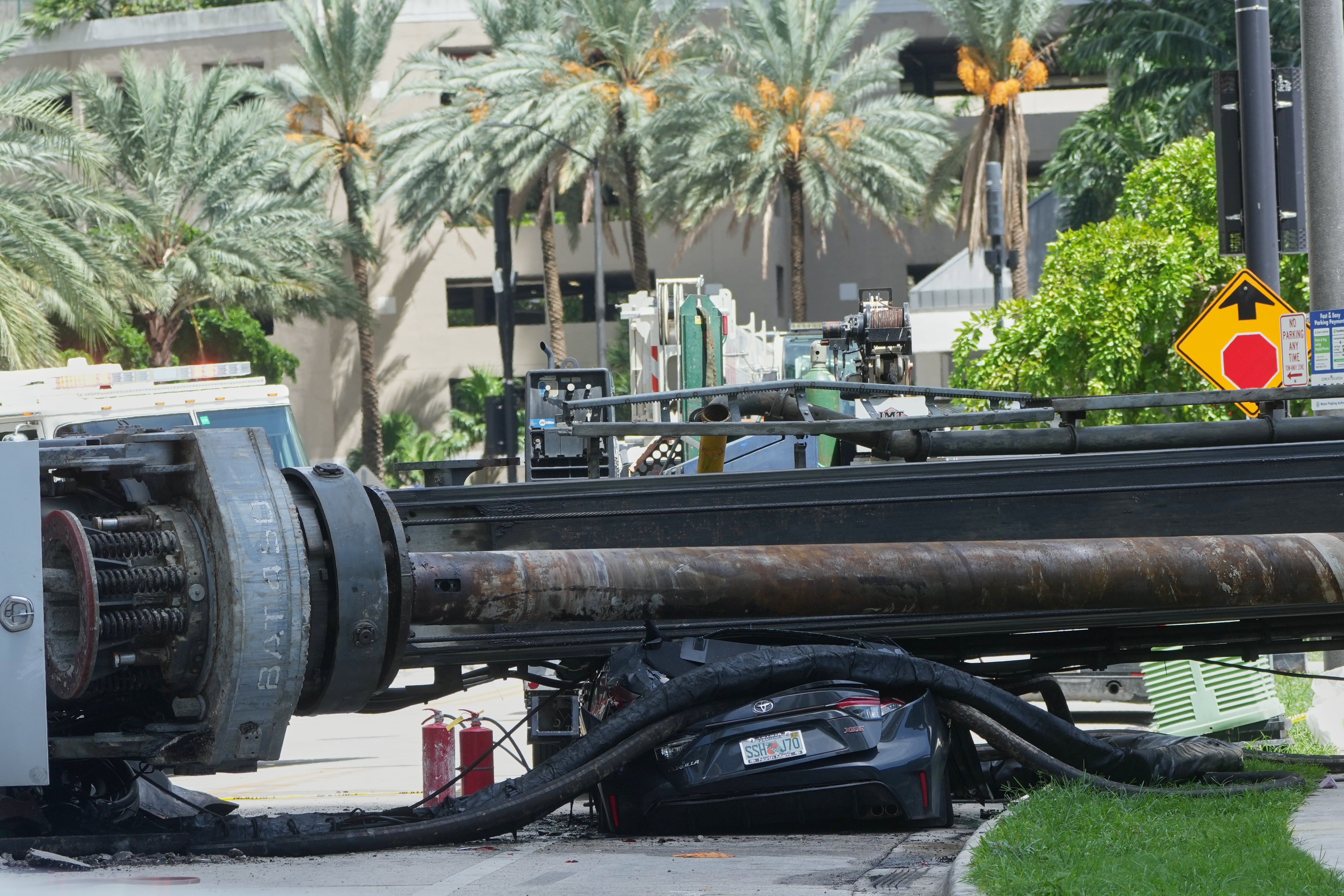 Four hospitalized after crane collapsed on moving car from Miami construction site, causing a fire