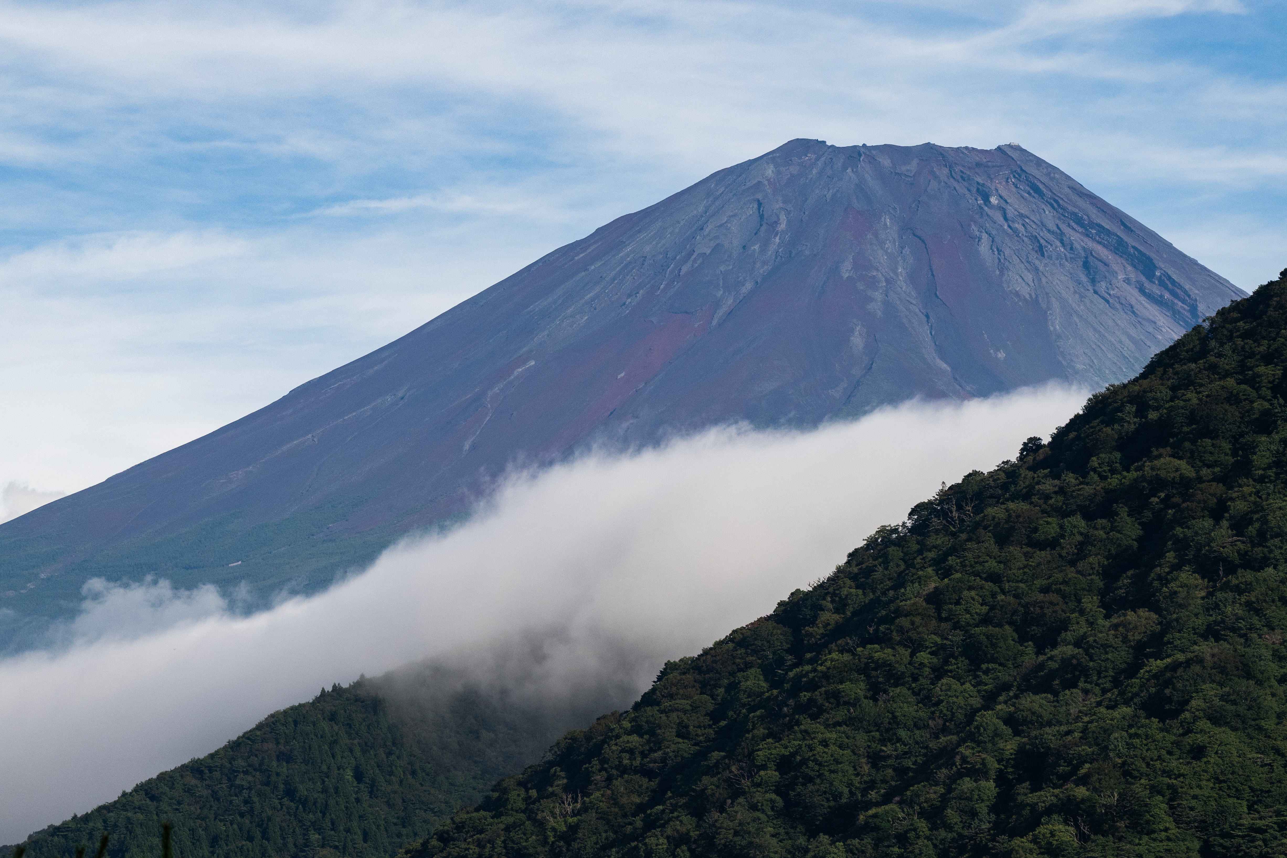 Mount Fuji is seen behind a smaller mountain on lake Motosu in Minobu, Yamanashi prefecture, on 30 August 2026 (AFP/Getty)