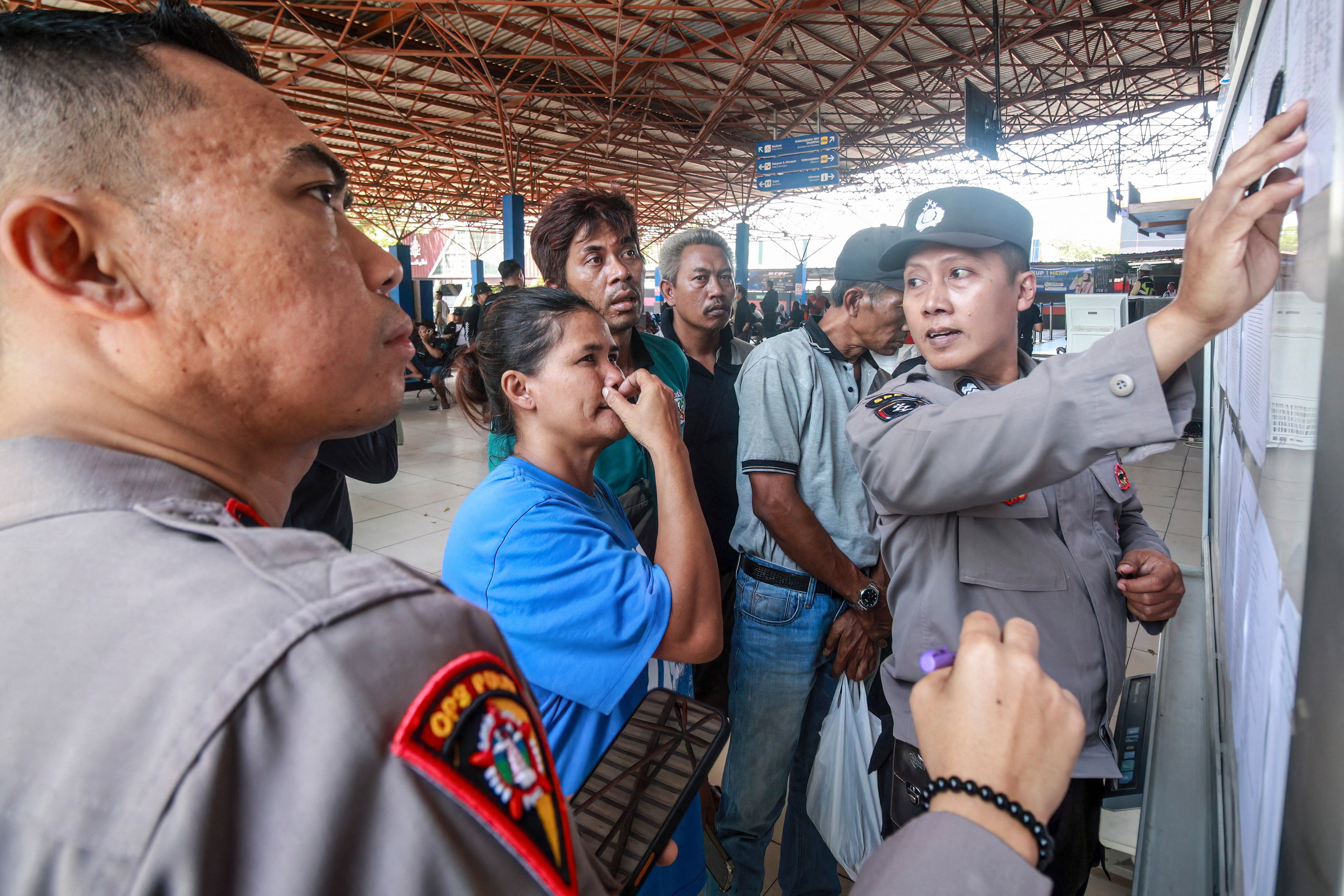 A woman reacts as police officers display a list of the victims of the Virgo Transport 8 ferry (AFP/Getty)