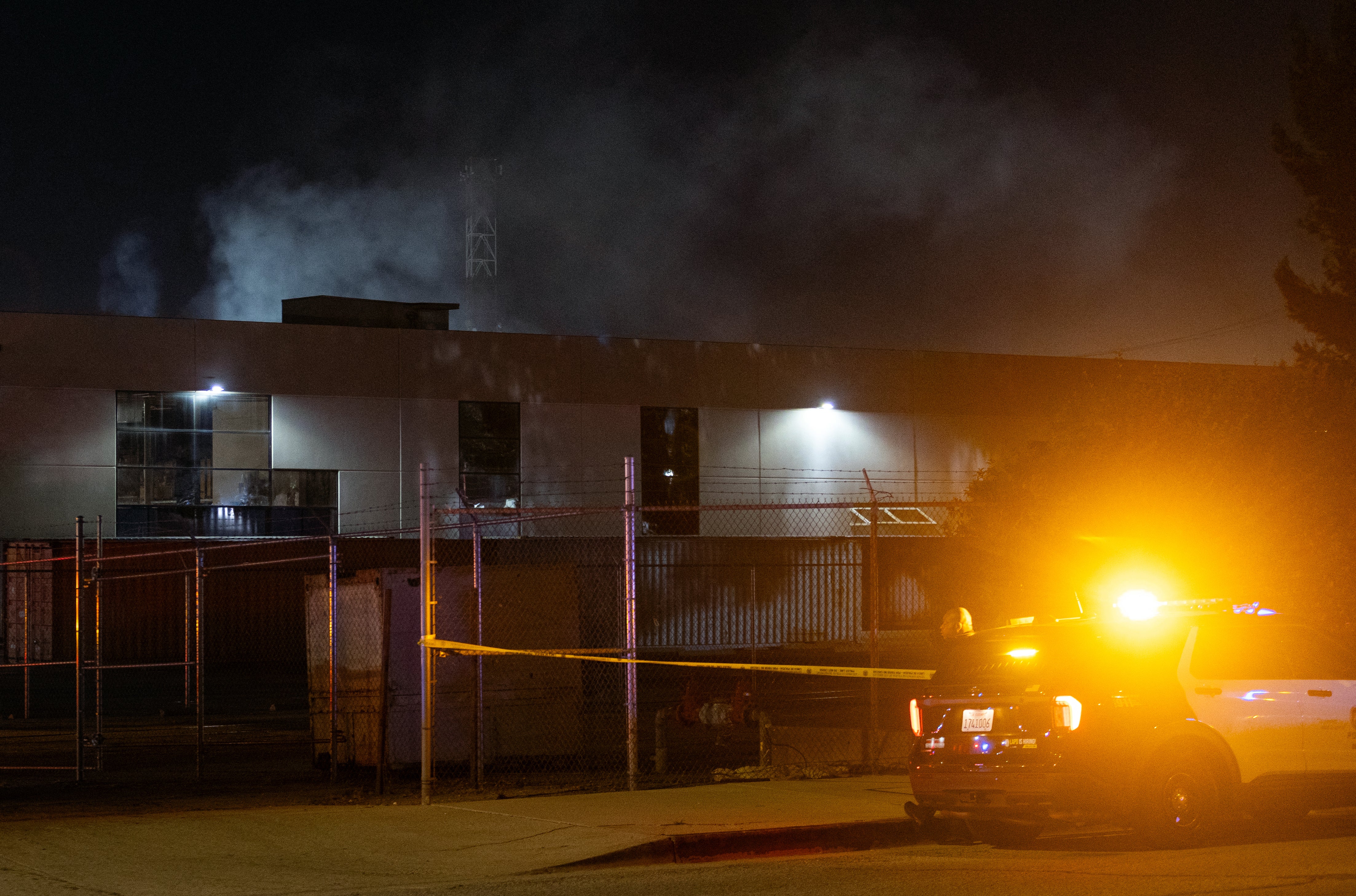 A Los Angeles Police officer stands guard near the scene after a news helicopter crashed in Chatsworth, a suburban neighborhood of Los Angeles