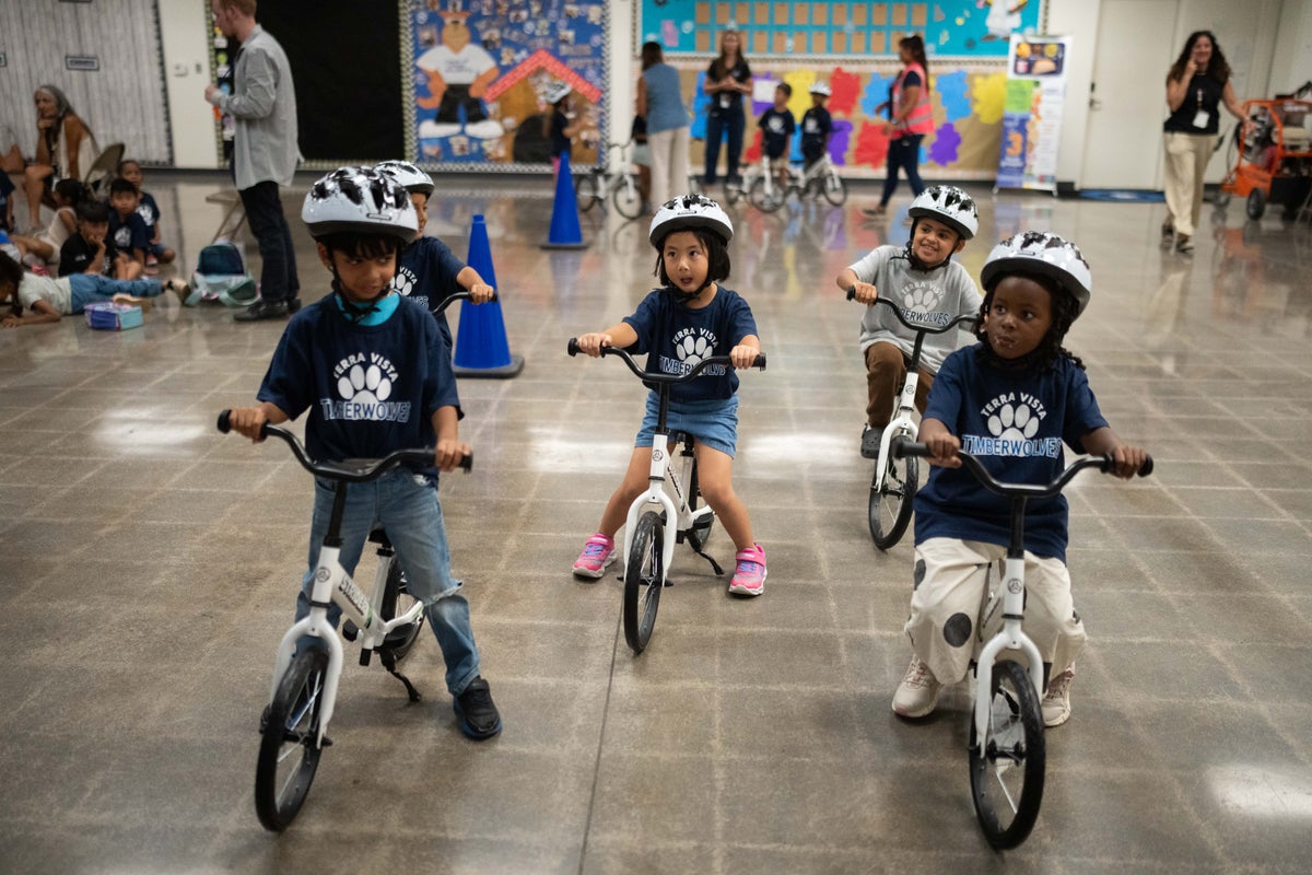 Kindergartners learn to ride bikes in school gyms as lessons move indoors