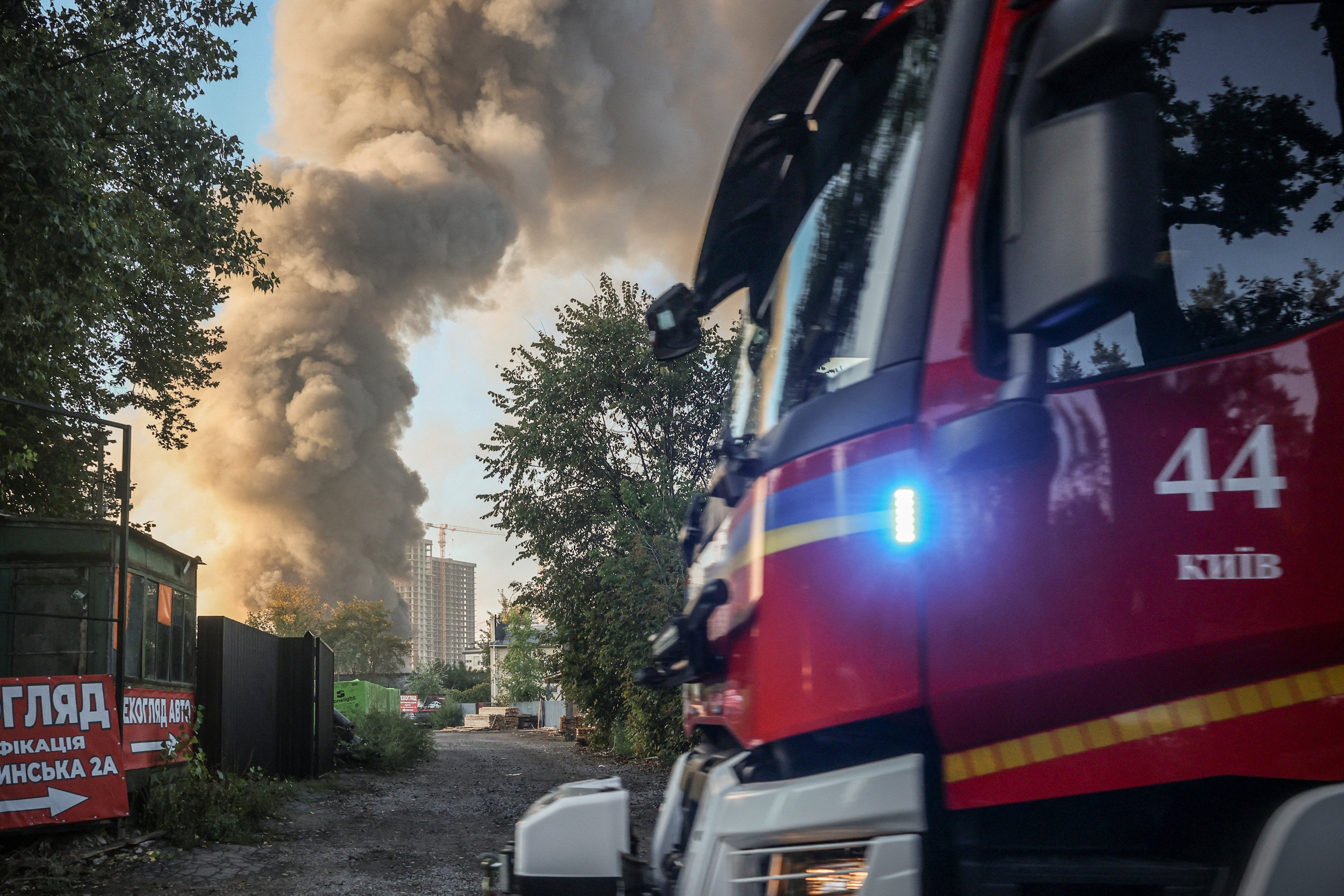 A firetruck drives by the site of a Russian drone strike as smoke rises in the background, amid Russia’s attack on Ukraine, in Kyiv, Ukraine September 16, 2026. (Reuters)