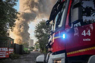 A firetruck drives by the site of a Russian drone strike as smoke rises in the background, amid Russia’s attack on Ukraine, in Kyiv, Ukraine September 16, 2026.
