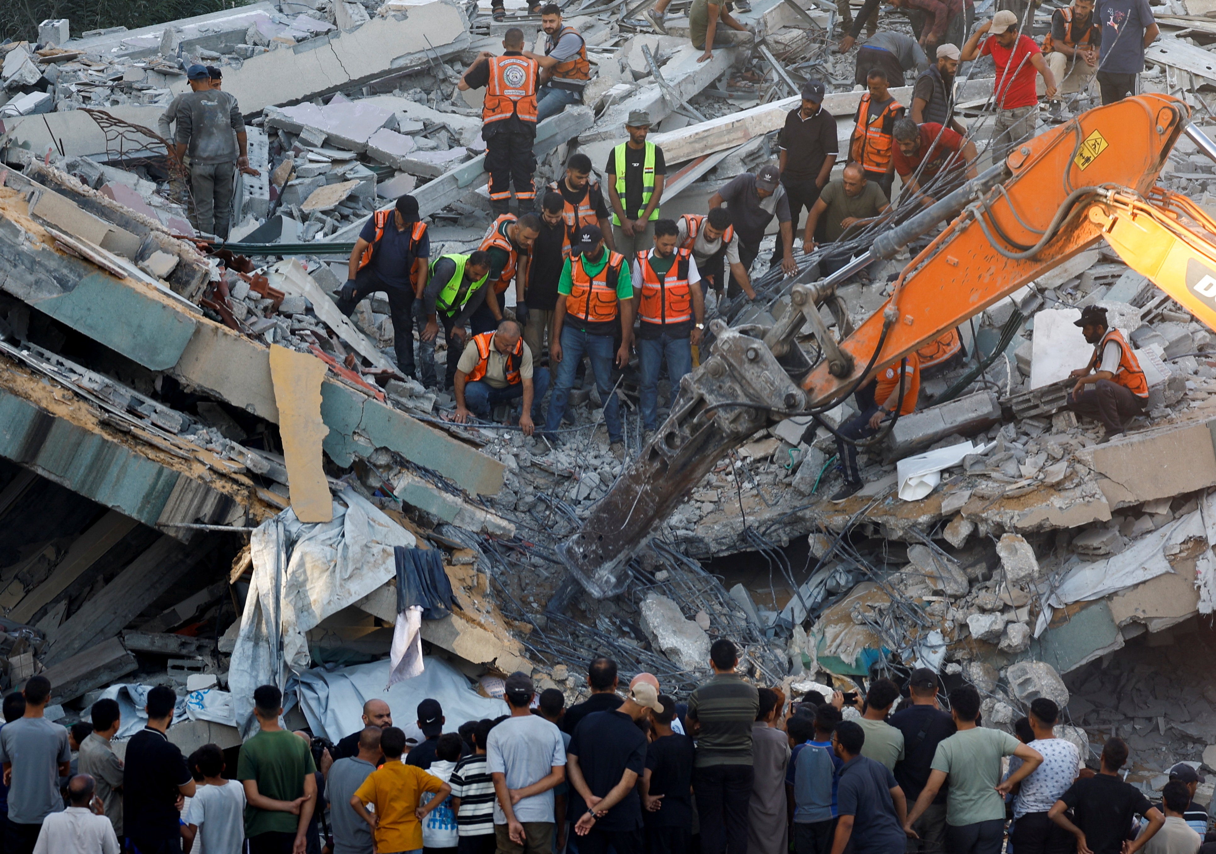 People gather as Civil Defence workers attempt to rescue those who are trapped beneath the rubble of a residential building that had been damaged in an earlier Israeli strike during the war and collapsed on Wednesday, in Gaza City, September 16, 2026 (Reuters)
