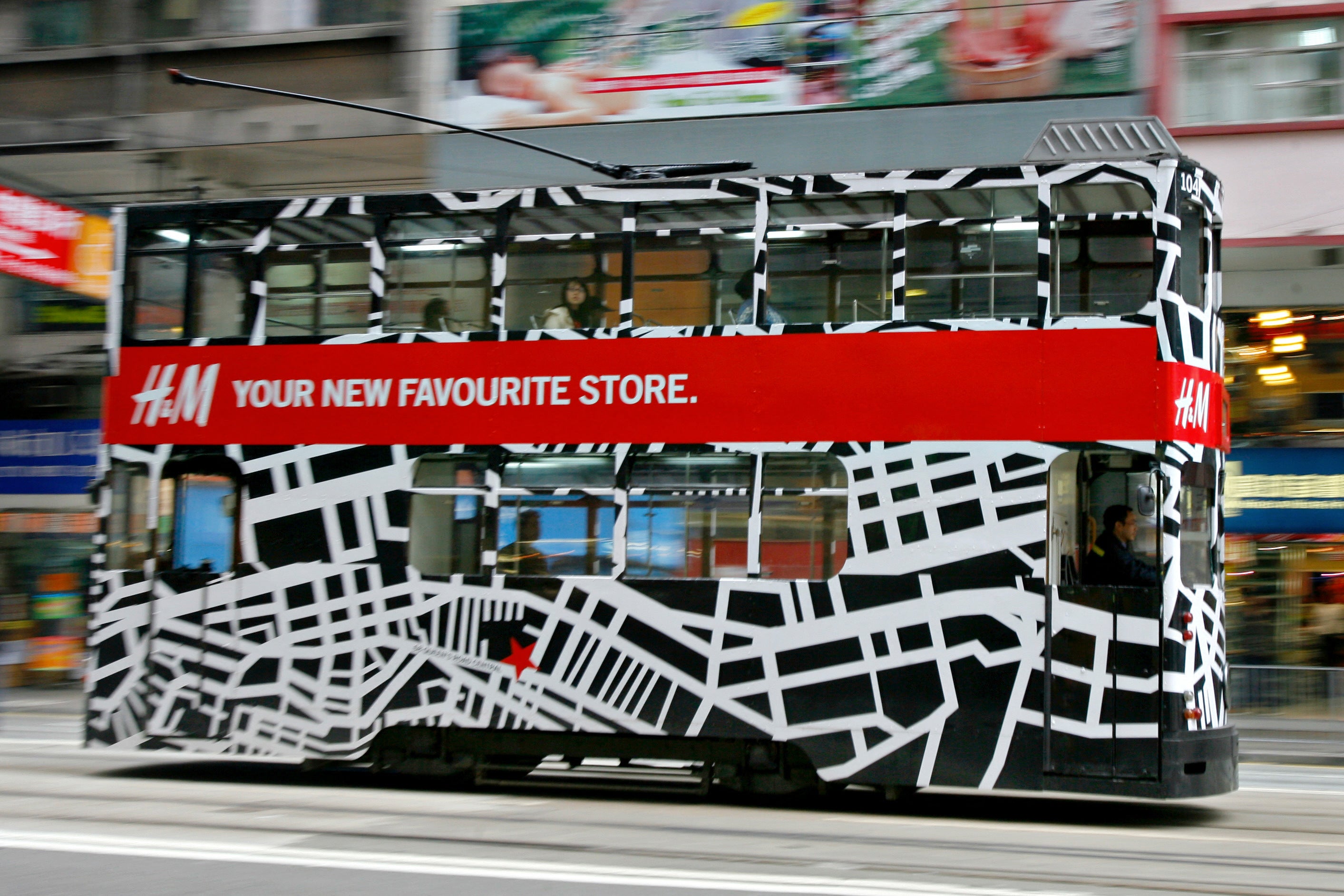 A bus wrapped in an ad for H&M, a fast fashion giant