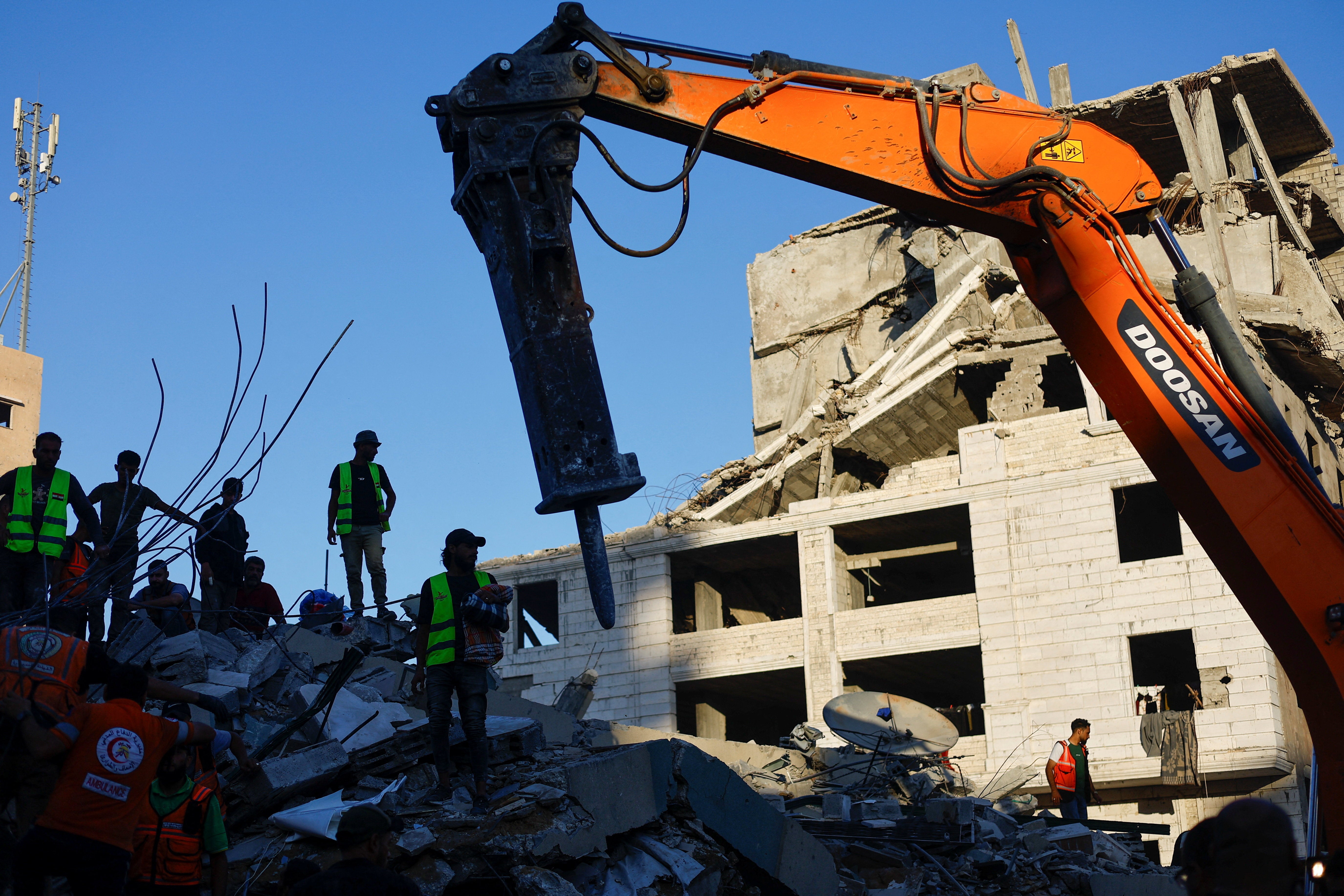 Civil Defence workers attempt to rescue people trapped beneath the rubble