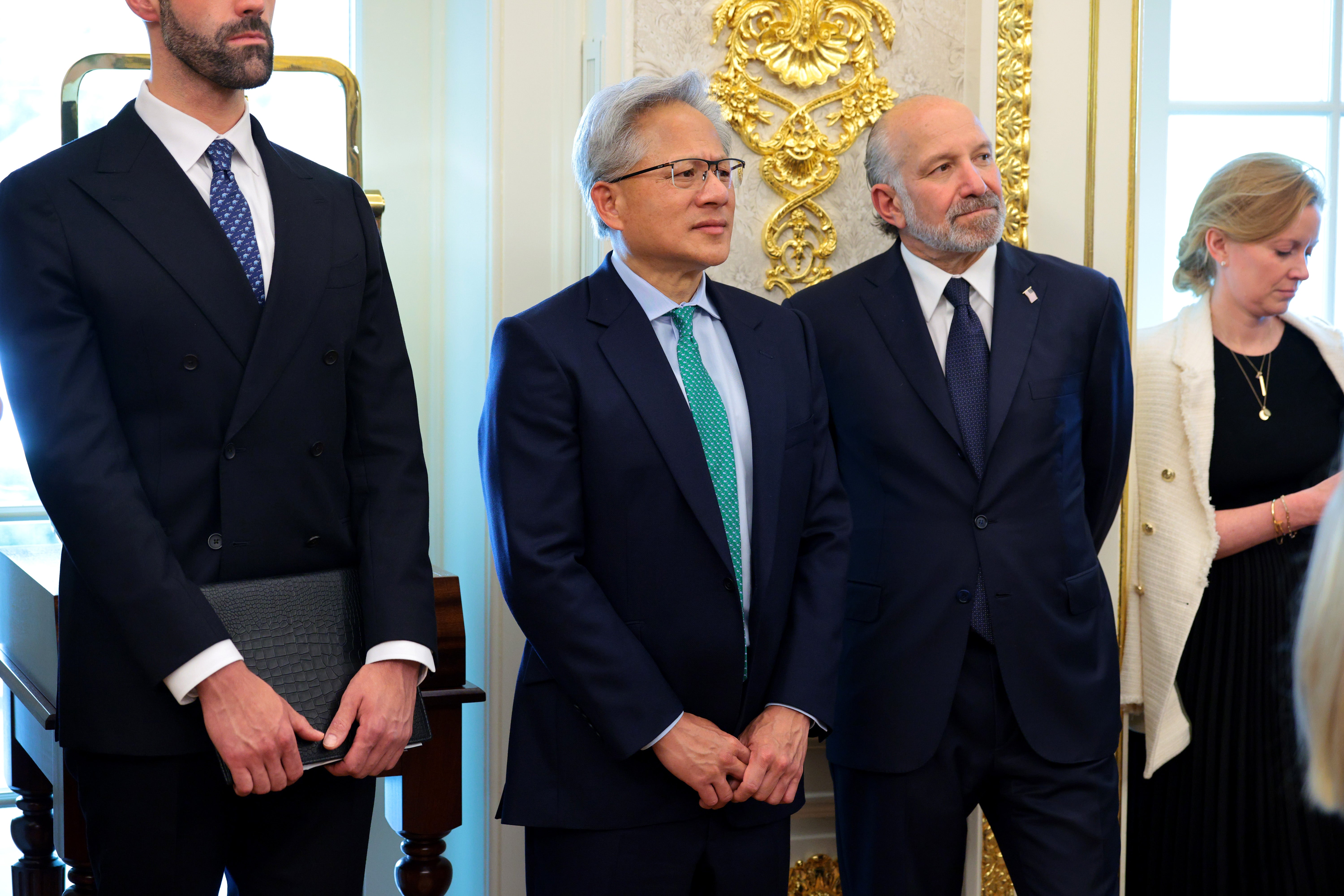 Huang (L) and U.S. Commerce Secretary Howard Lutnick listen during an announcement to renovate Washington Dulles International Airport, in the Oval Office of the White House on July 29,