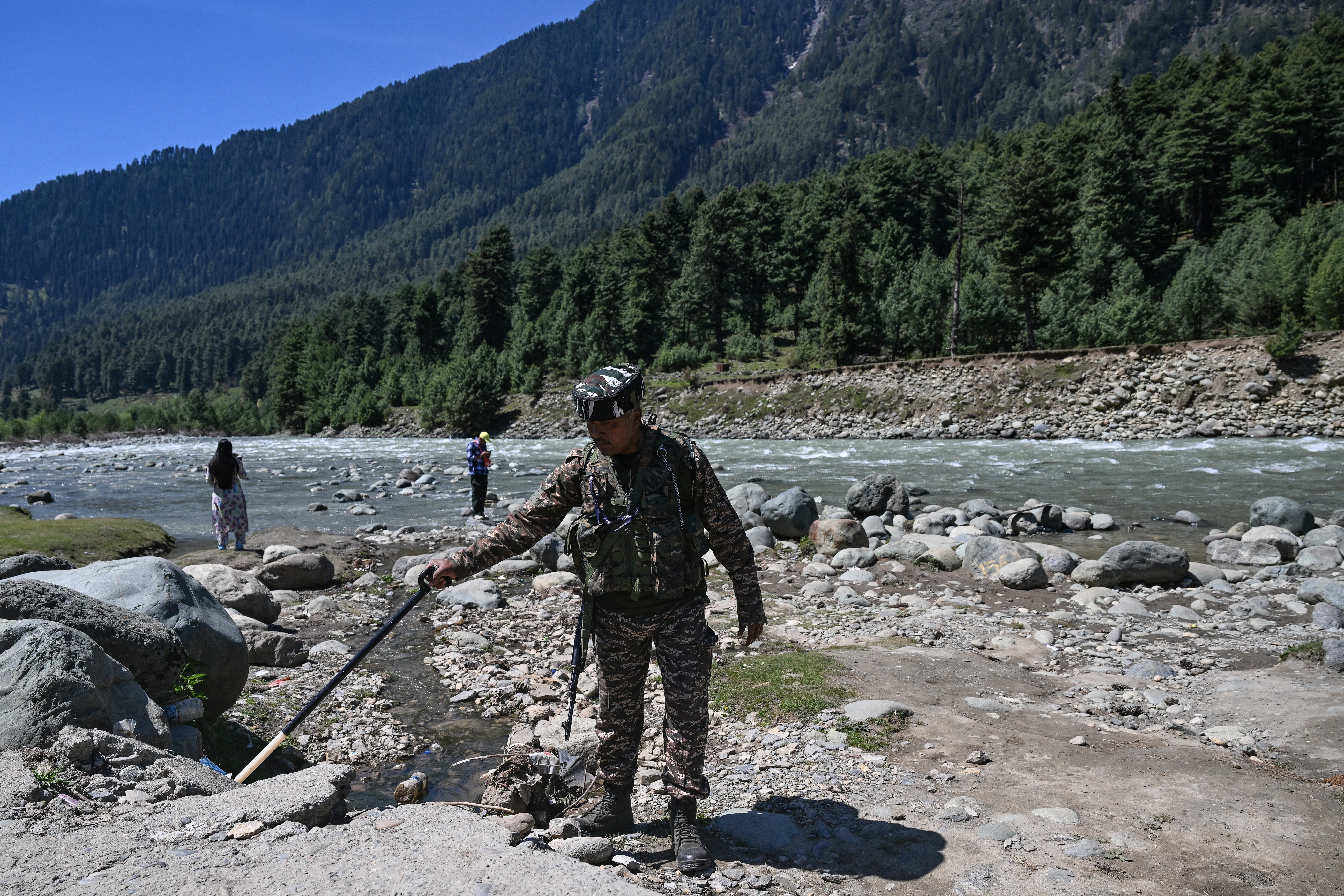 An Indian paramilitary personnel searches for explosives using a metal detector along the banks of Lidder river in Pahalgam, in south Kashmir's Anantnag district on 22 April 2026 that marks the first anniversary of the Pahalgam attack which killed 26 men, mostly Hindu tourists (AFP/Getty)