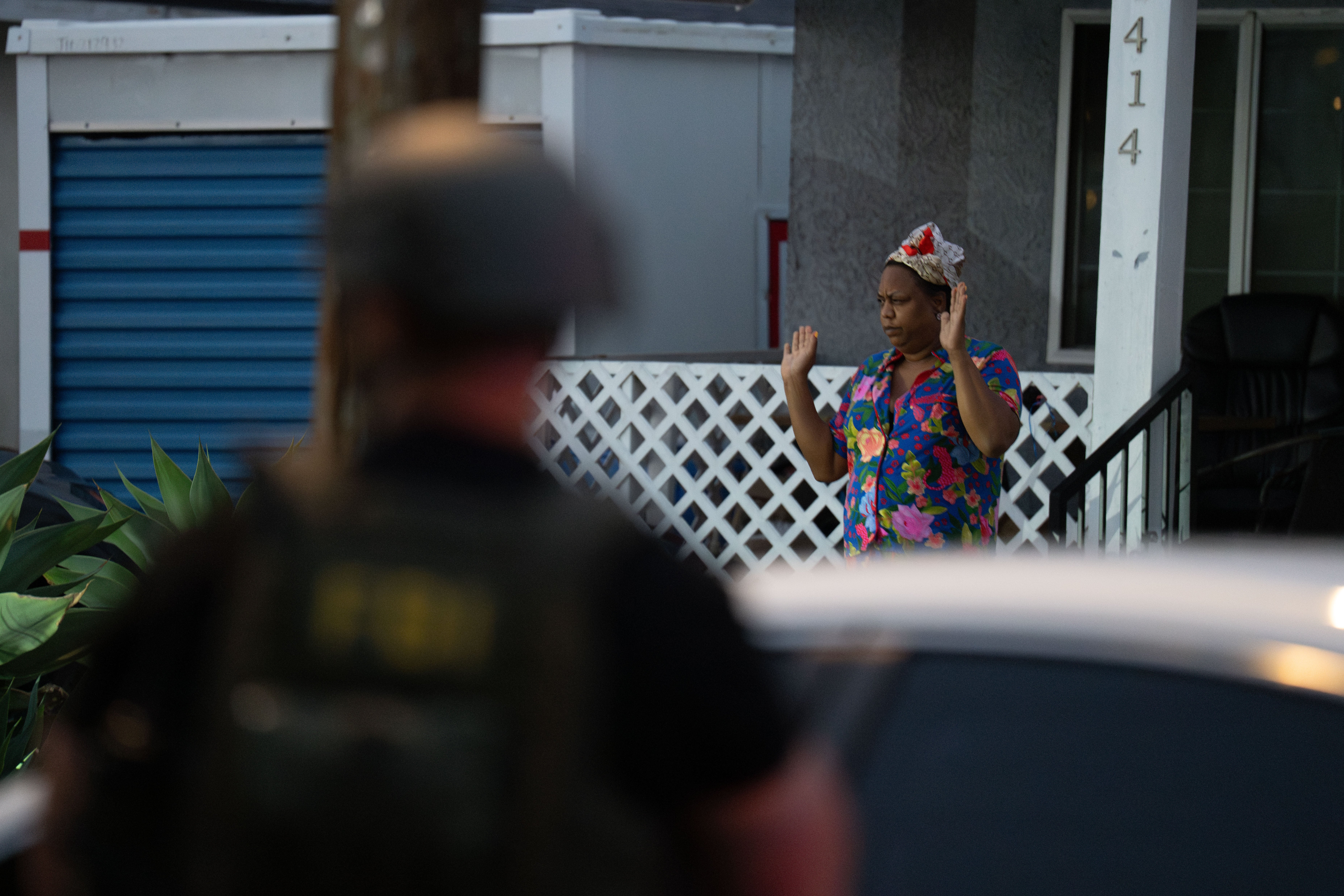 Lakiya Malone, charged with fraud involving federal homelessness aid programs, walks out of her home toward federal authorities