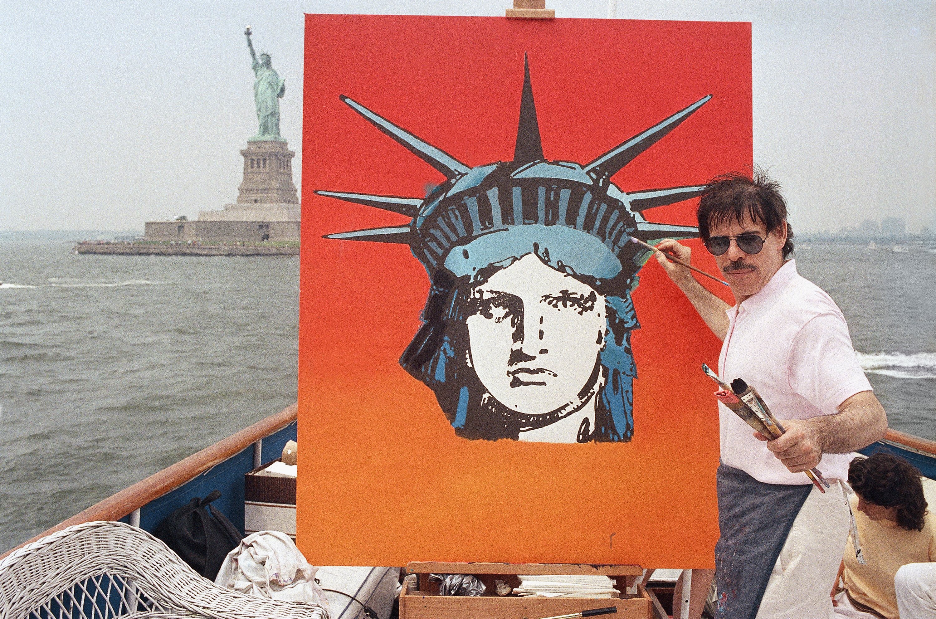 Peter Max works on a painting of the Statue of Liberty in 1987 (AP)