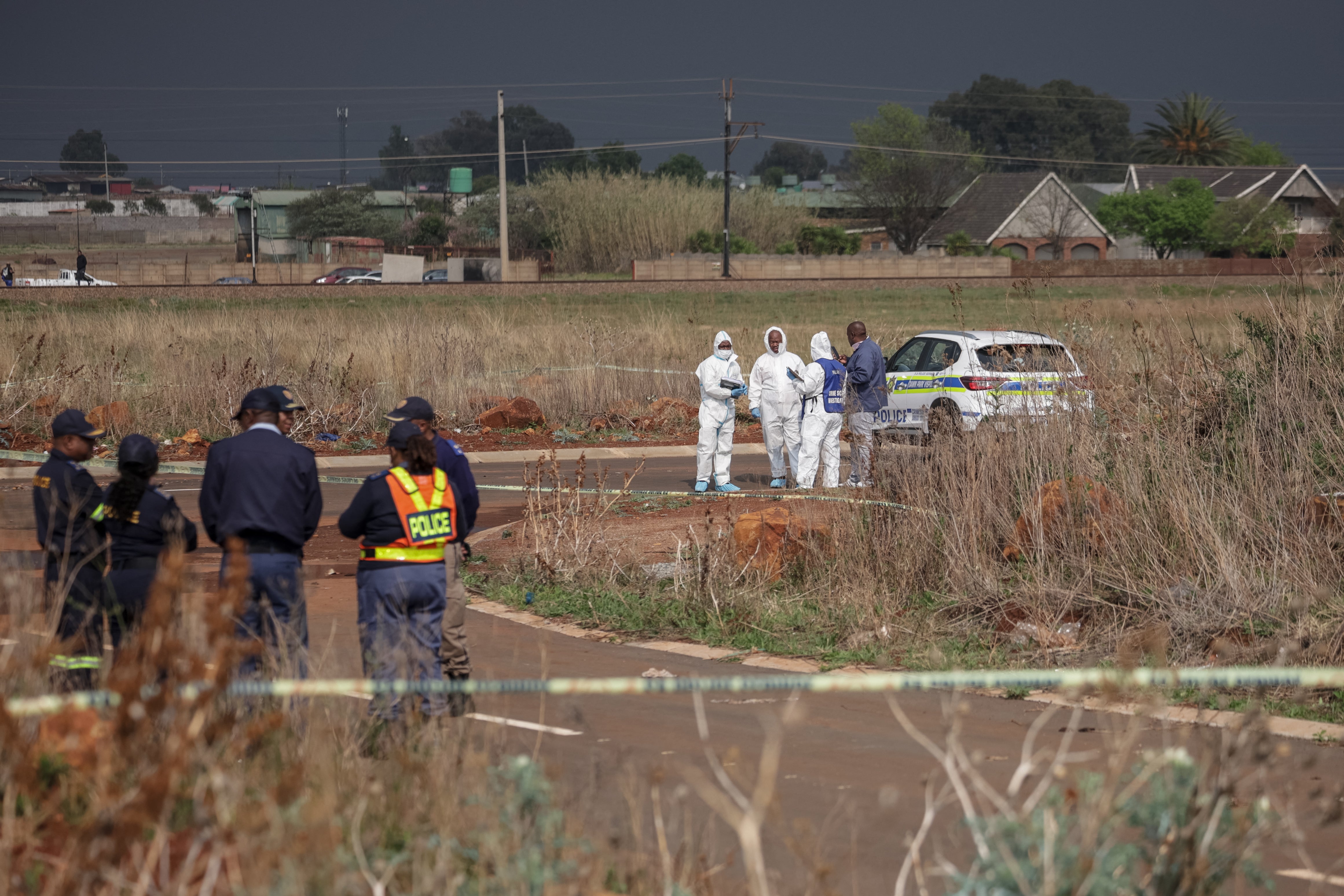 Members of the South African Police Service (SAPS) Forensic Pathology Services work on the crime scene where the body of a woman was discovered in Boksburg