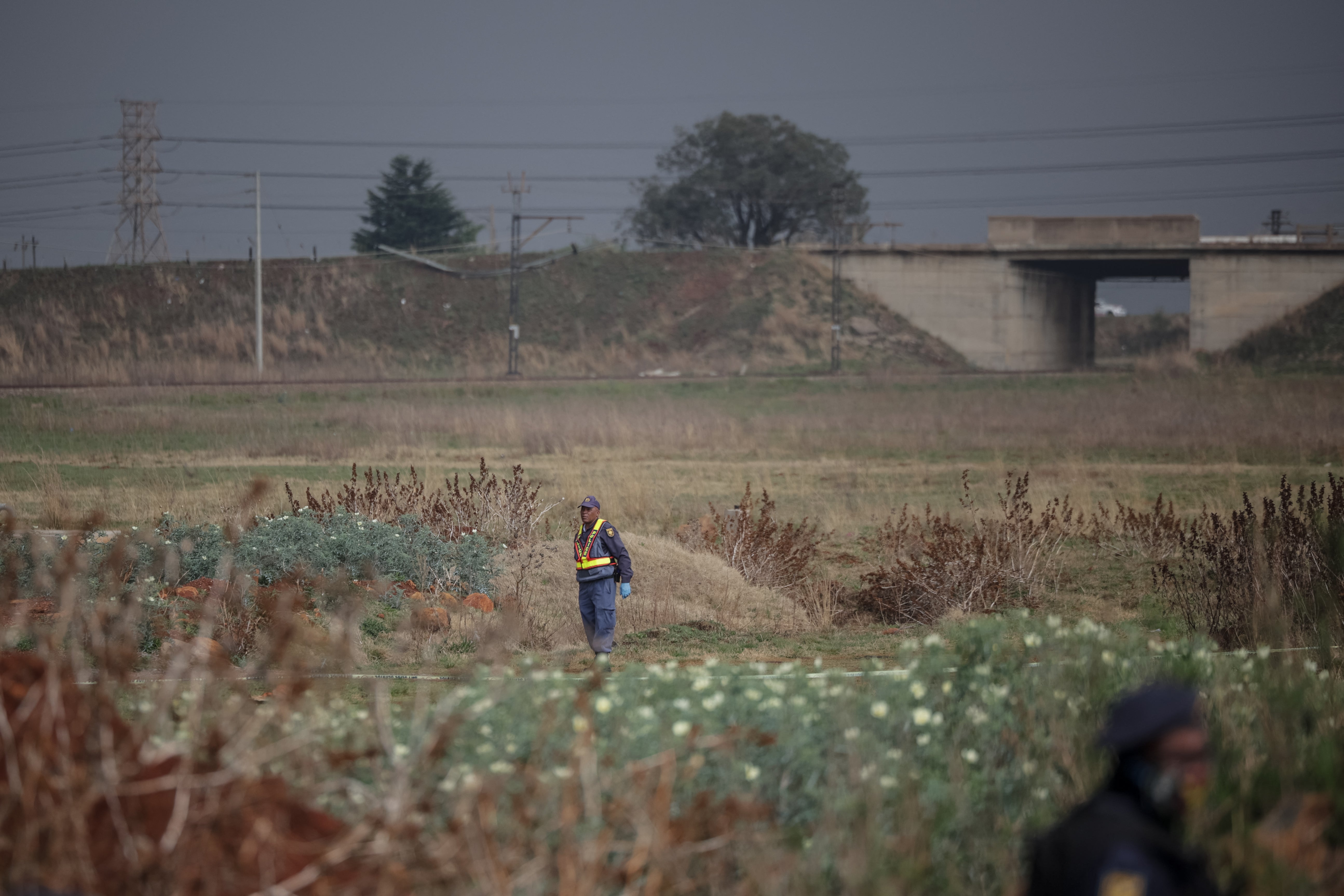 South African Police Service (SAPS) officers stand guard at the crime scene where the body of a woman was discovered in Boksburg. (AFP/Getty)