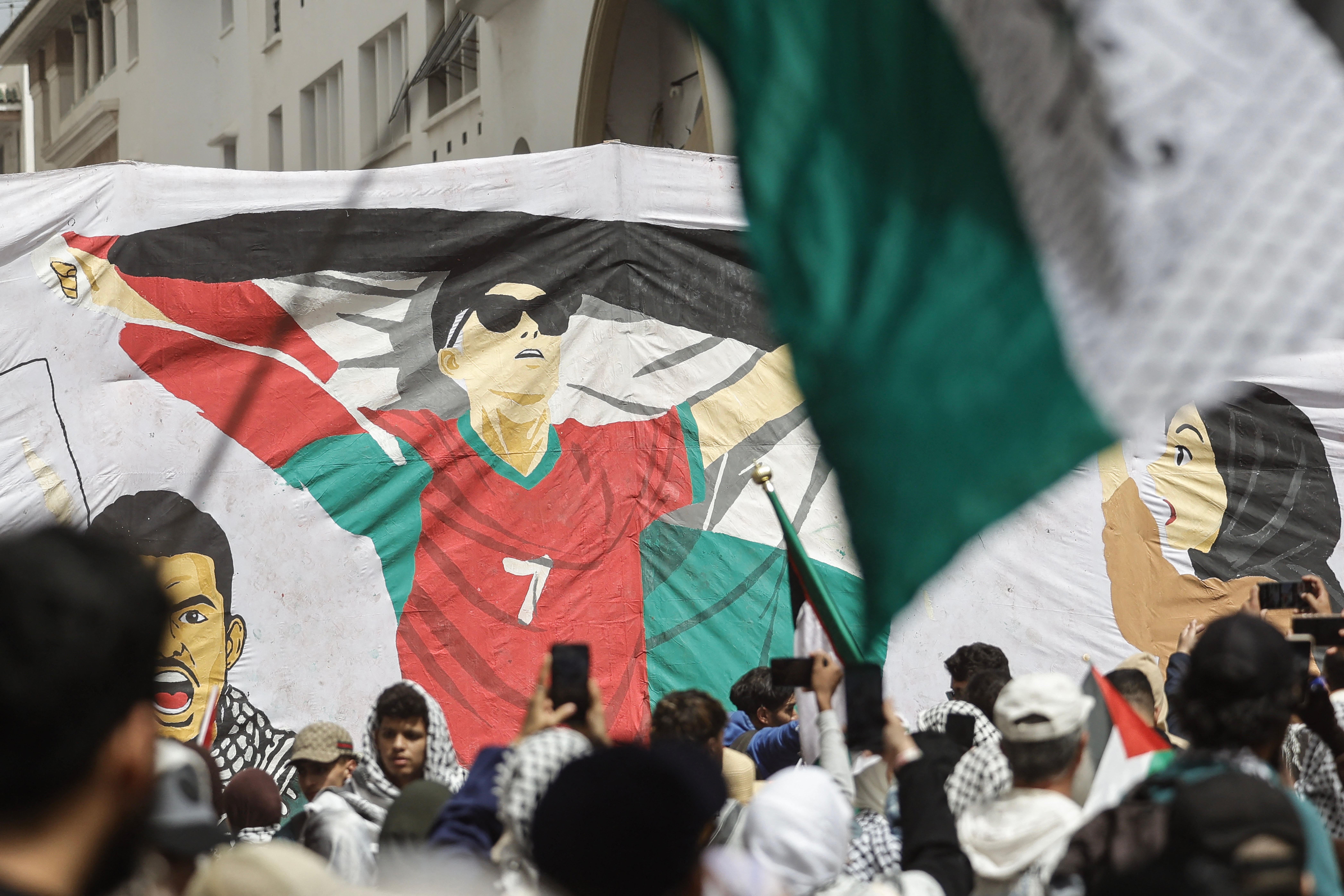 Protesters raise a banner depicting Moroccan football player Hakim Ziyech during a rally in support of the Palestinian people and against Israel's approval of a death penalty bill, in Rabat on April 19, 2026.