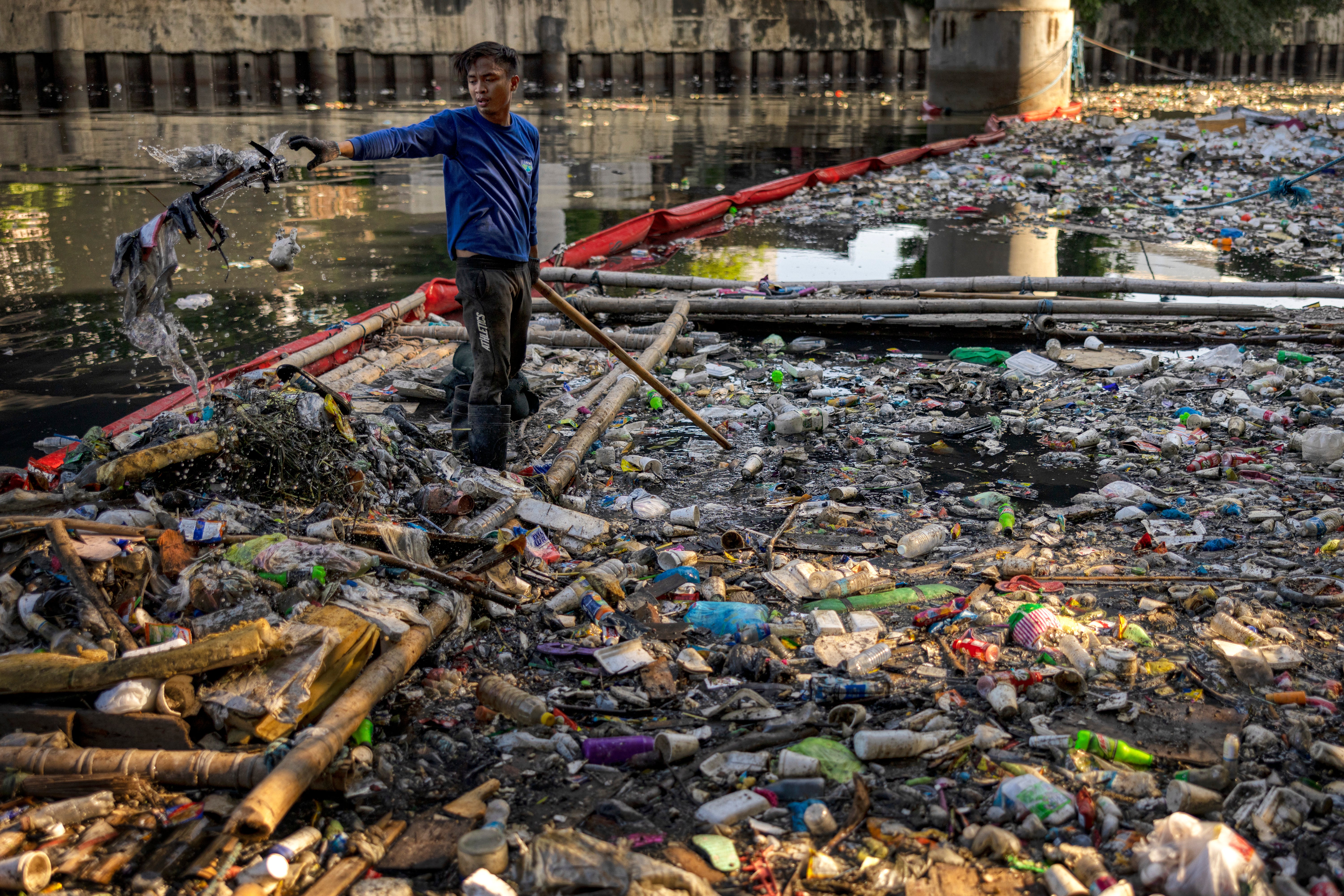 A ‘river warrior’ collects plastic waste from San Juan river in Manila, Philippines (Getty)