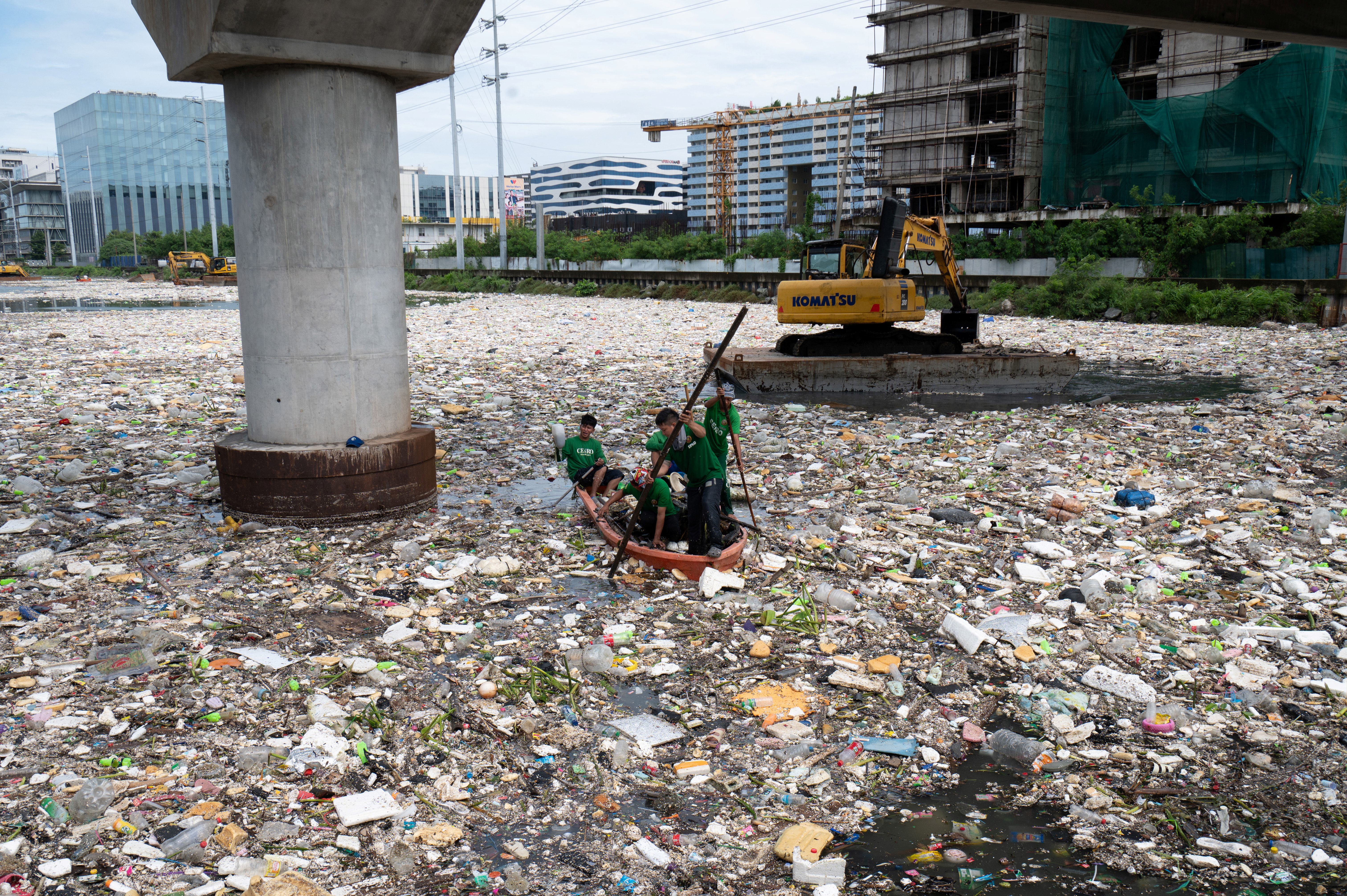 Workers on a plastic boat collect rubbish from a river in Paranaque City, suburban Manila, Philippines (AFP/Getty)