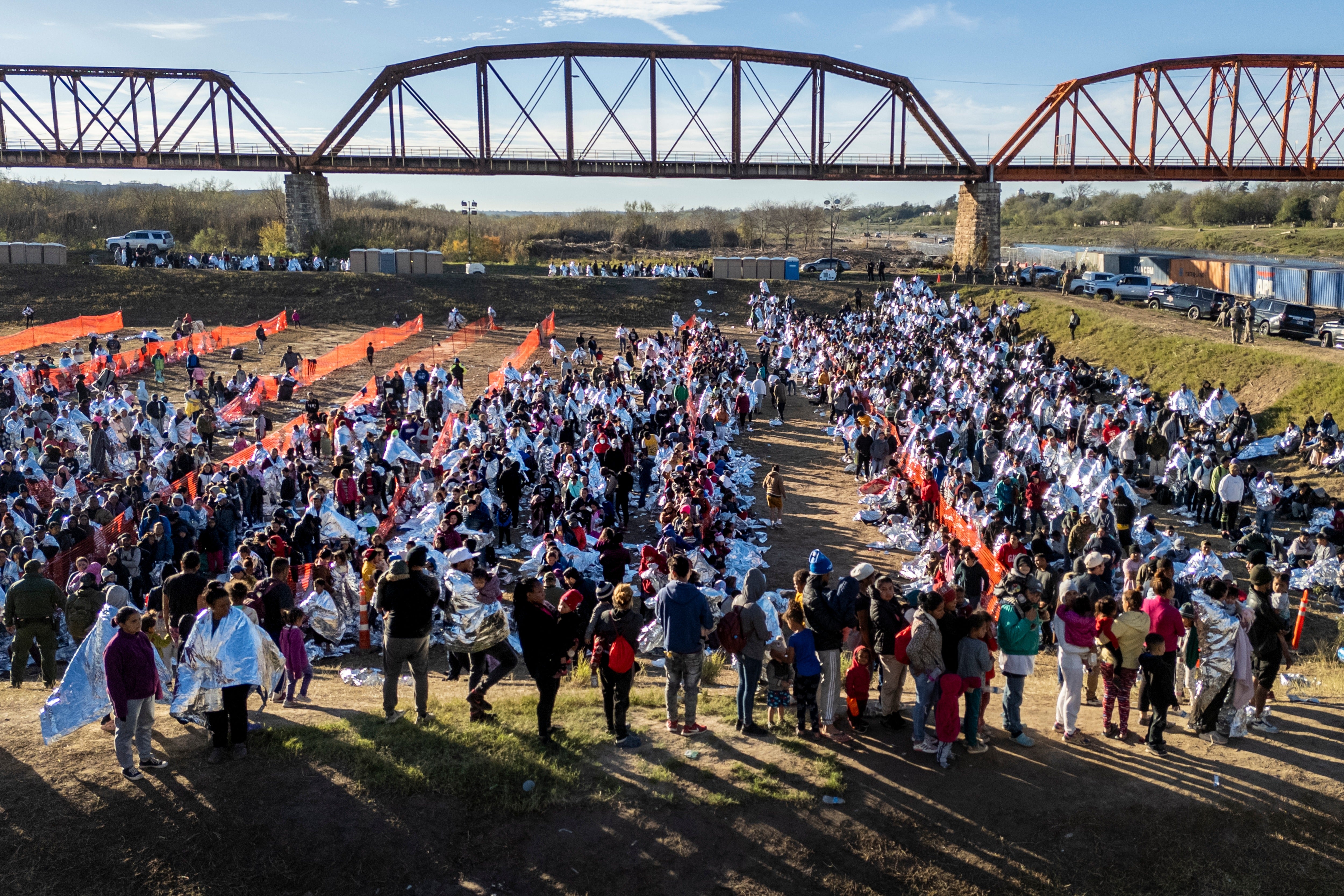 Thousands of immigrants, most wearing thermal blankets, await processing at a U.S. Border Patrol transit center on December 19, 2023 in Eagle Pass, Texas