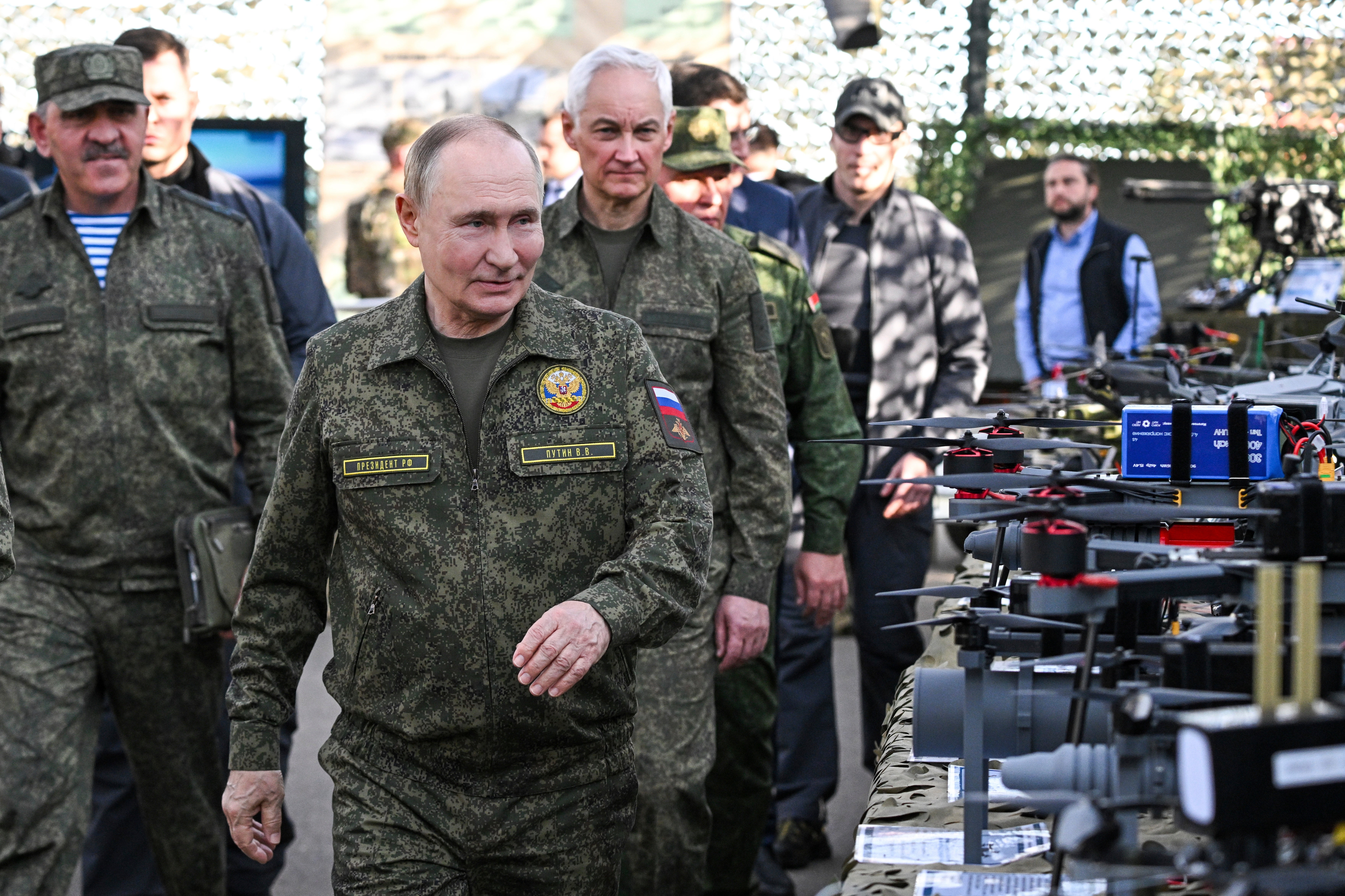 Russian President Vladimir Putin, accompanied by Deputy Defence Minister Yunus-Bek Yevkurov, left, and Defence Minister Andrei Belousov, right, inspects weapons and equipment during military drills at the Mulino training ground