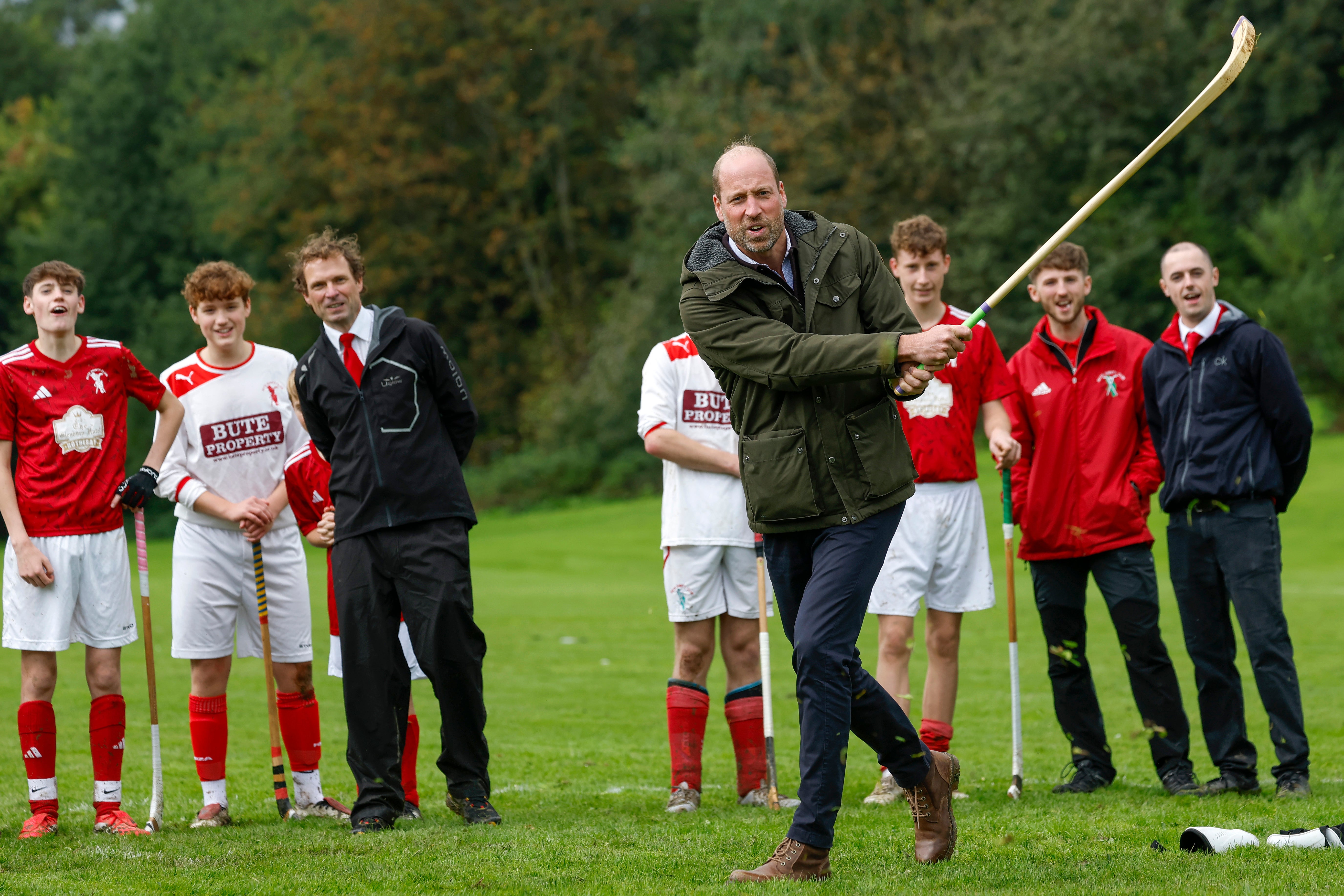 The Prince of Wales (known as the Duke of Rothesay when in Scotland) has a drink as participates in the sport on the pitch, while visiting the Bute Shinty Club.