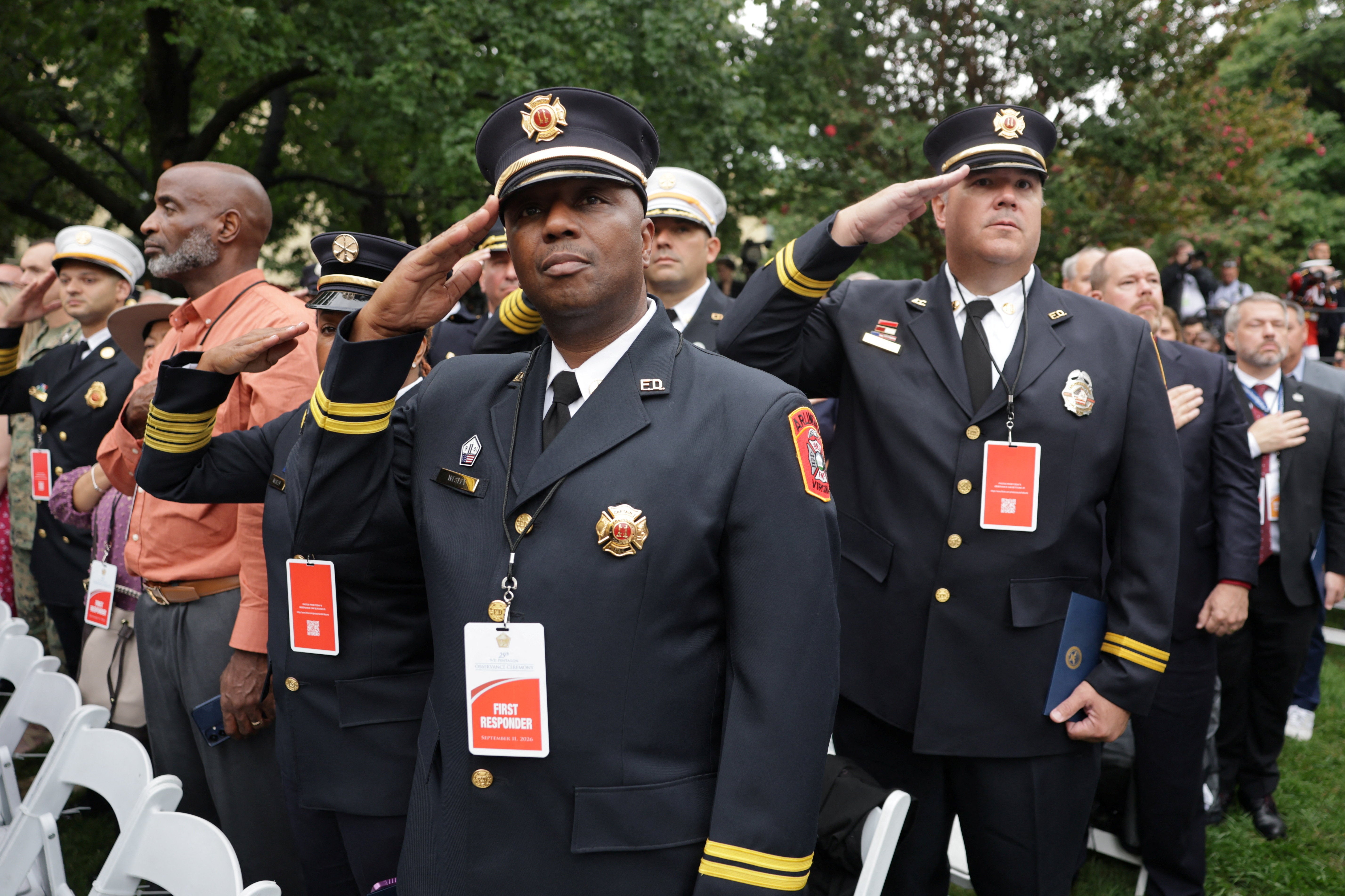 First responders salute during an observance ceremony marking the 25th anniversary of the September 11, 2001