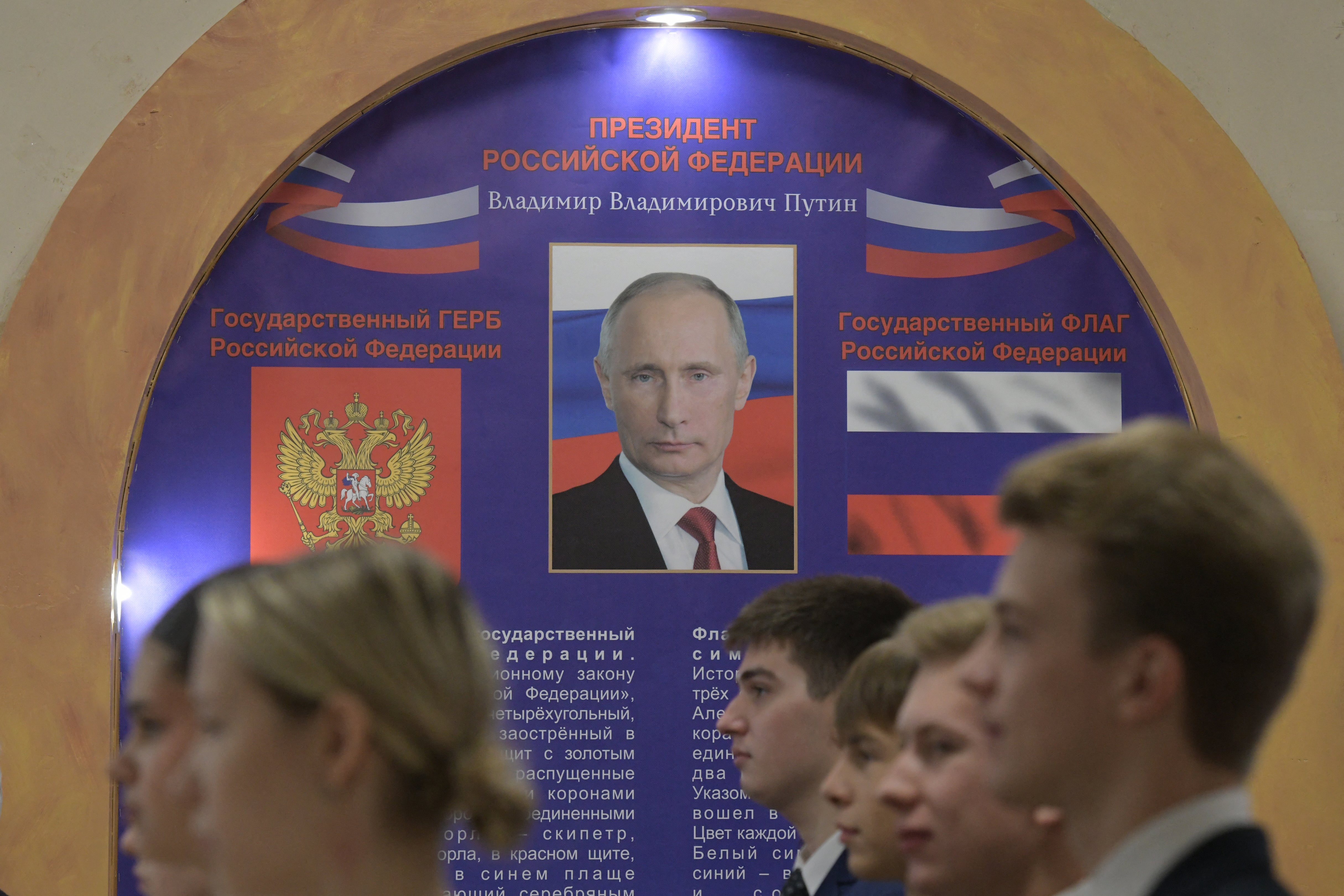 Students line up to sing the Russian national anthem as polls opened in Donetsk