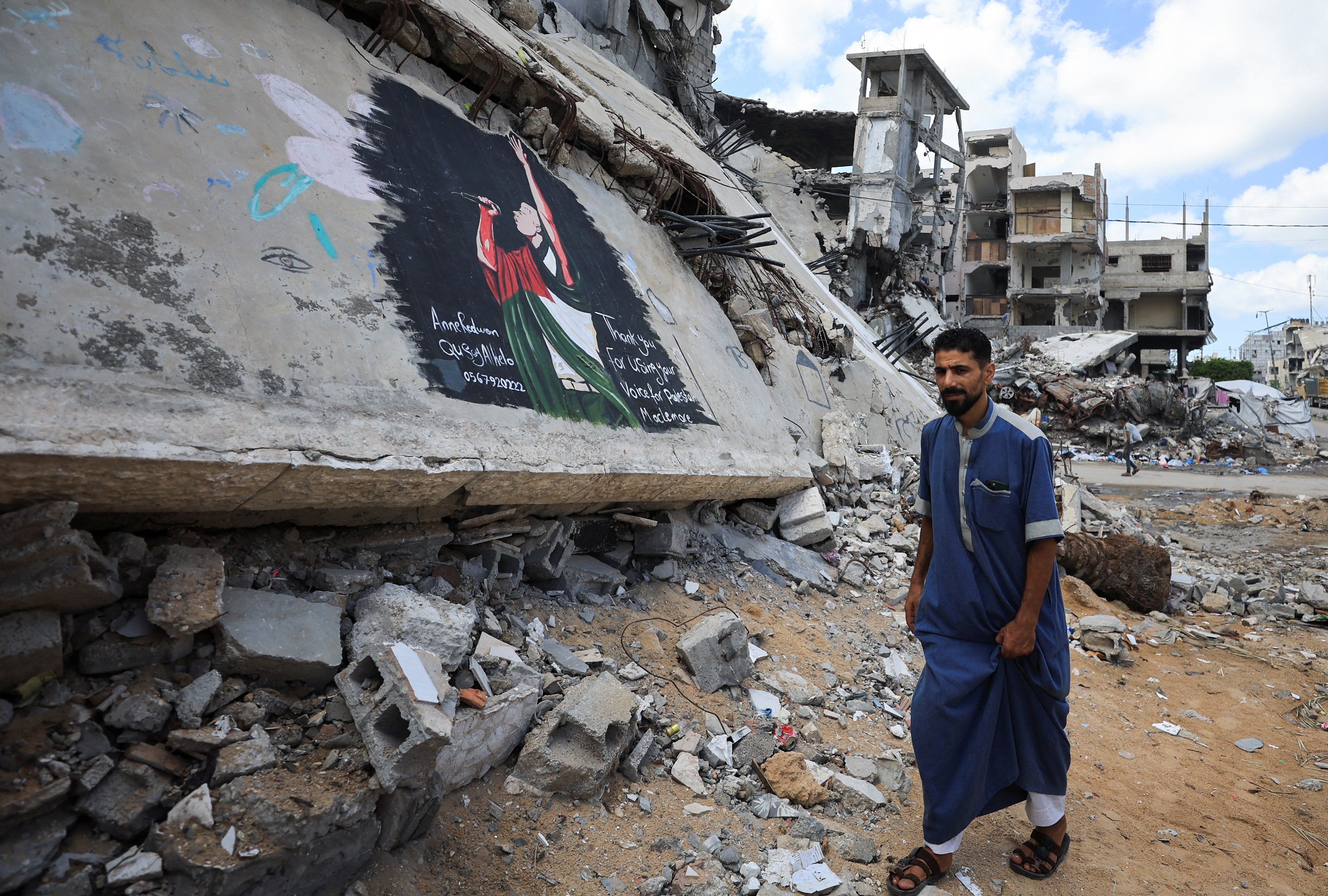 Palestinian walks past a mural painted in honour of American rapper Macklemore