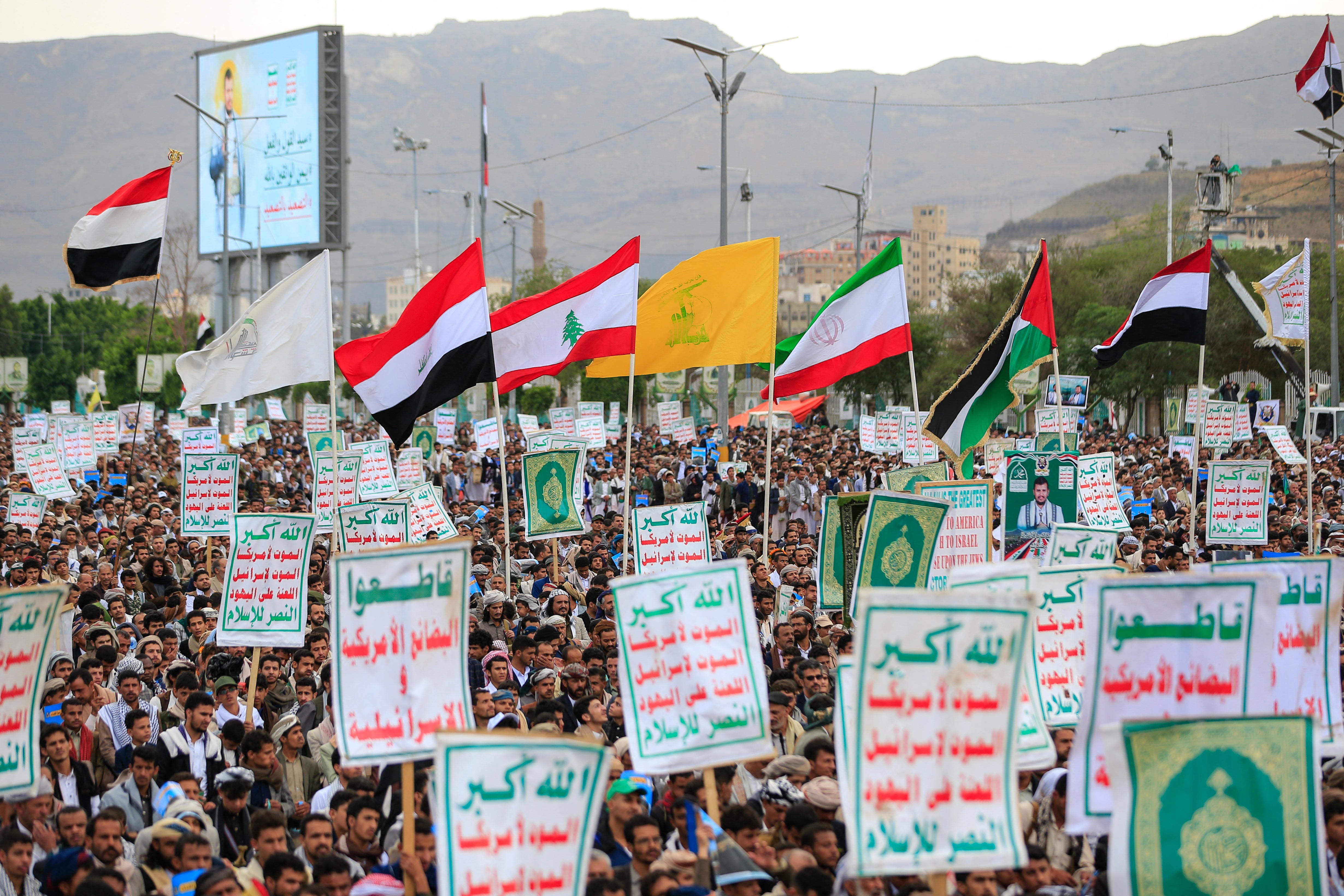 Supporters of Ansar Allah hold flags during a protest against Saudi intervention in Yemen on Friday