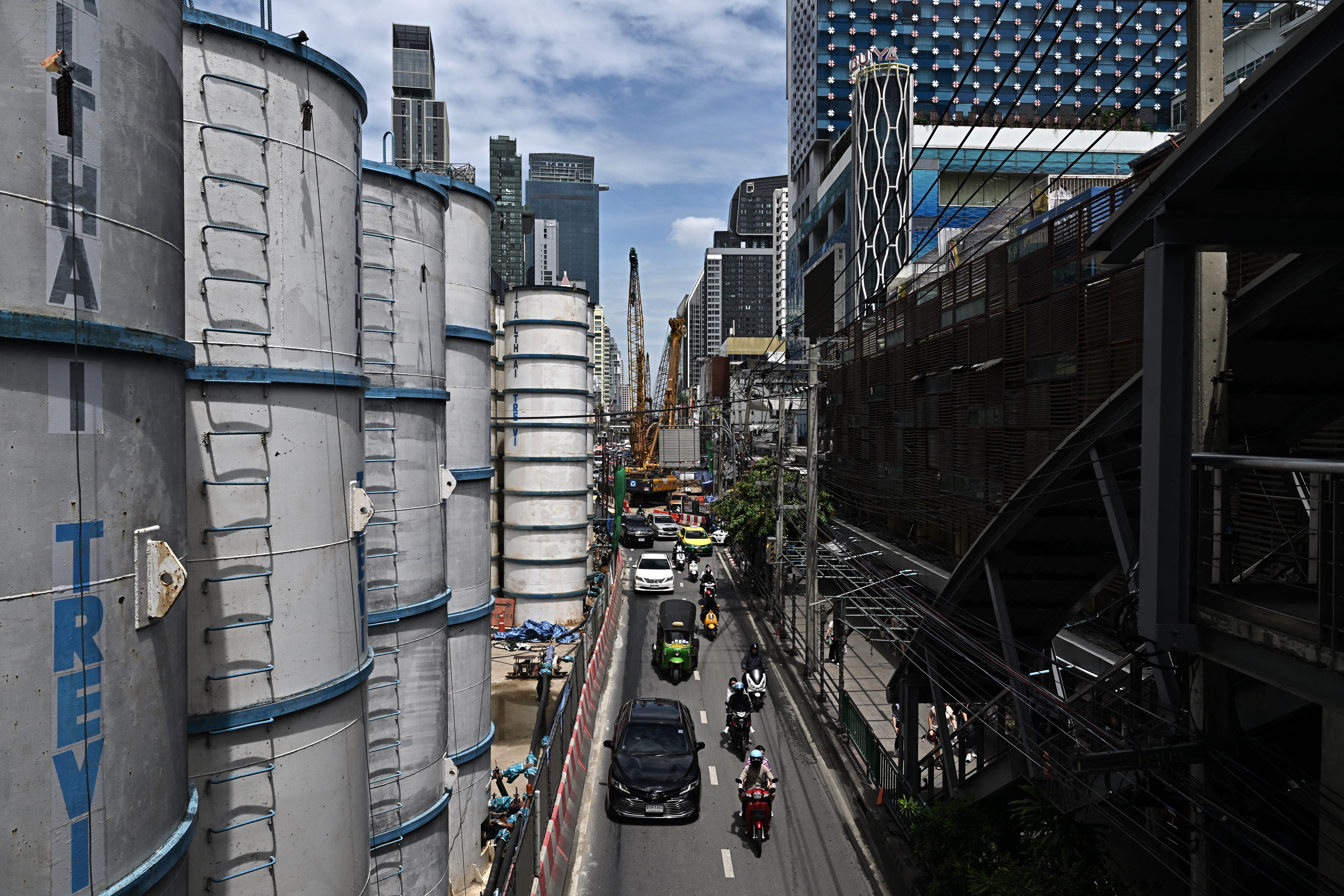 Motorists drive through a narrow lane in front of a construction site for a new MRT rail line near Pratunam intersection in Bangkok (AFP/Getty)