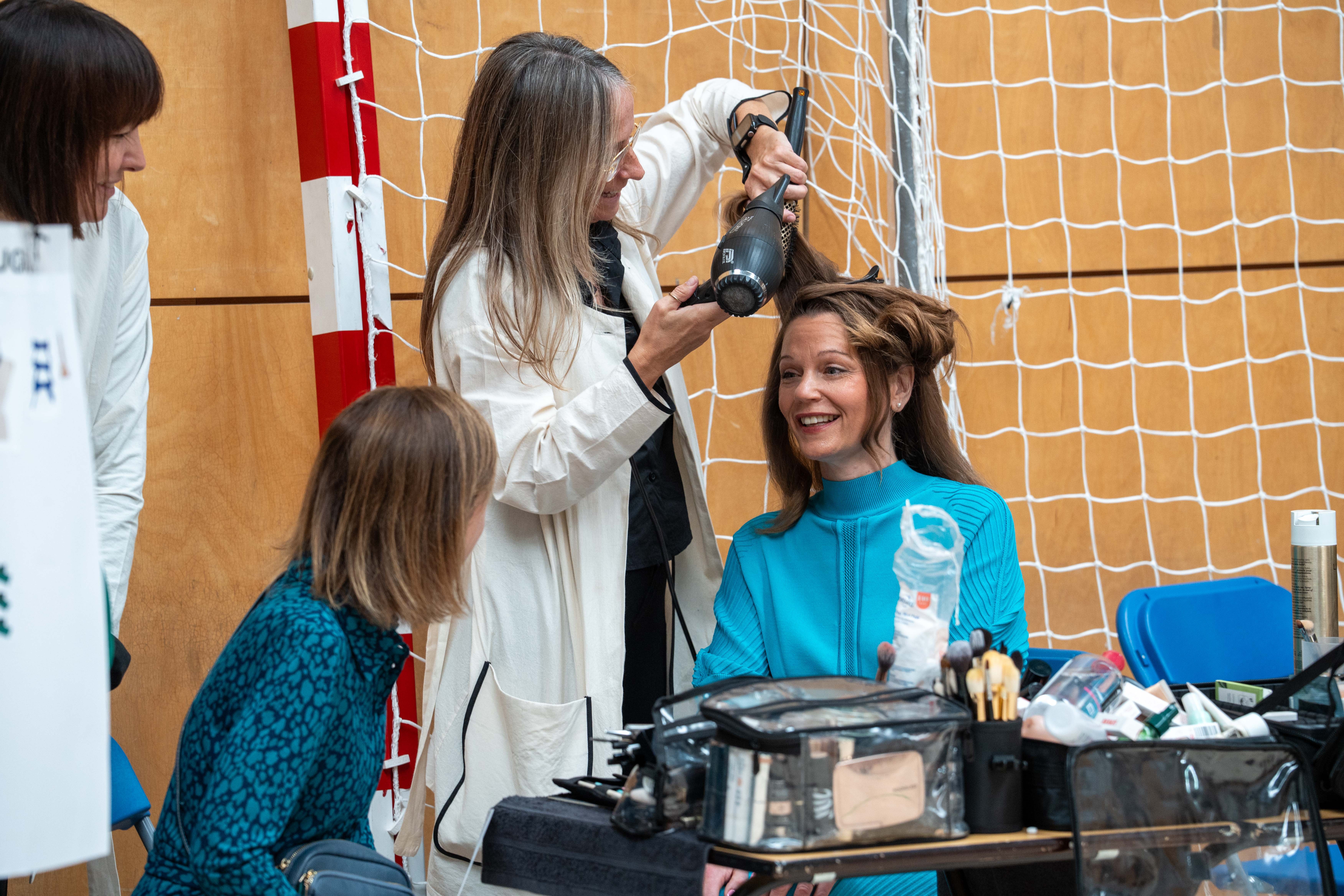 The former prime minister’s wife took part in Lee’s spring/summer 2027 show in a north London school sports hall, wearing a bright turquoise knitted midi dress with a high neckline, pleated detailing and short, sculptural sleeves